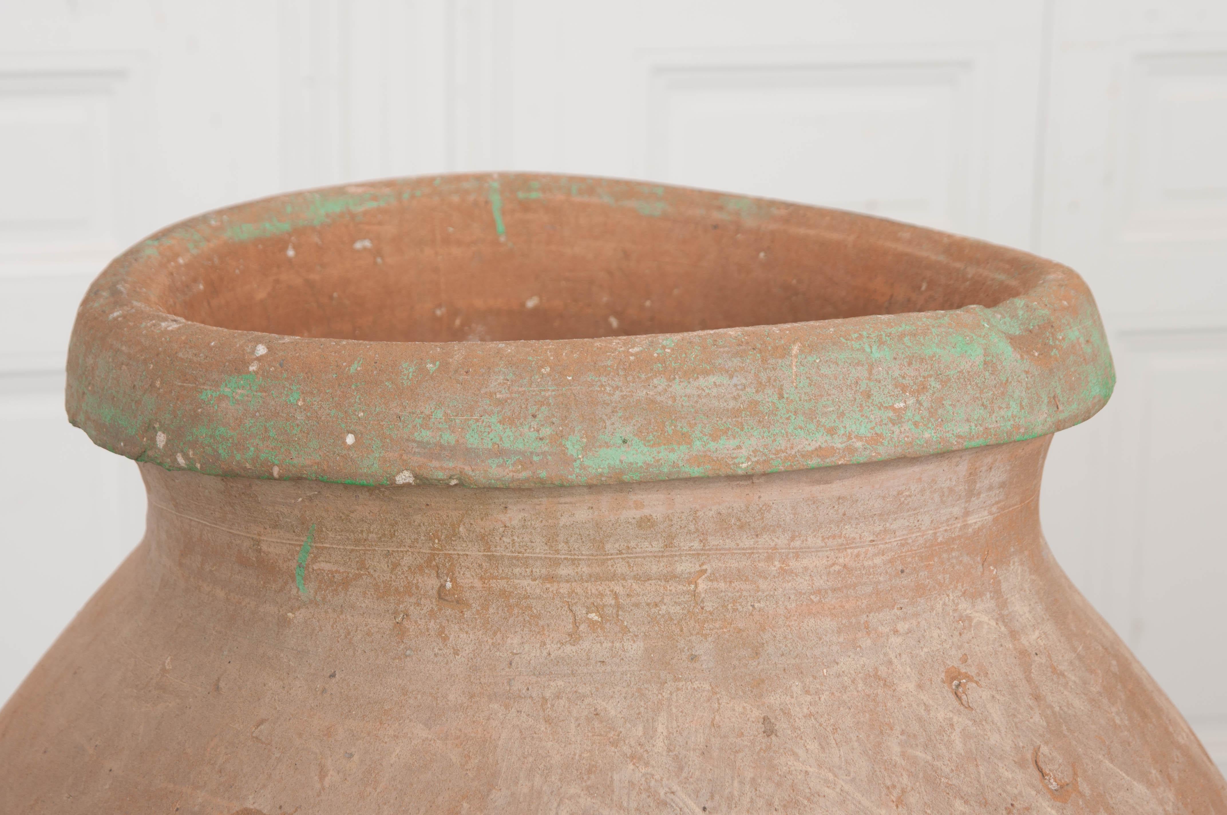 This large antique olive jar on stand is from Provincial France, circa 1850s, and would be the perfect addition to any garden. The unglazed olive jar, of elegant tapered form, is a beautiful shade of pale red and the wrought iron Stand retains much