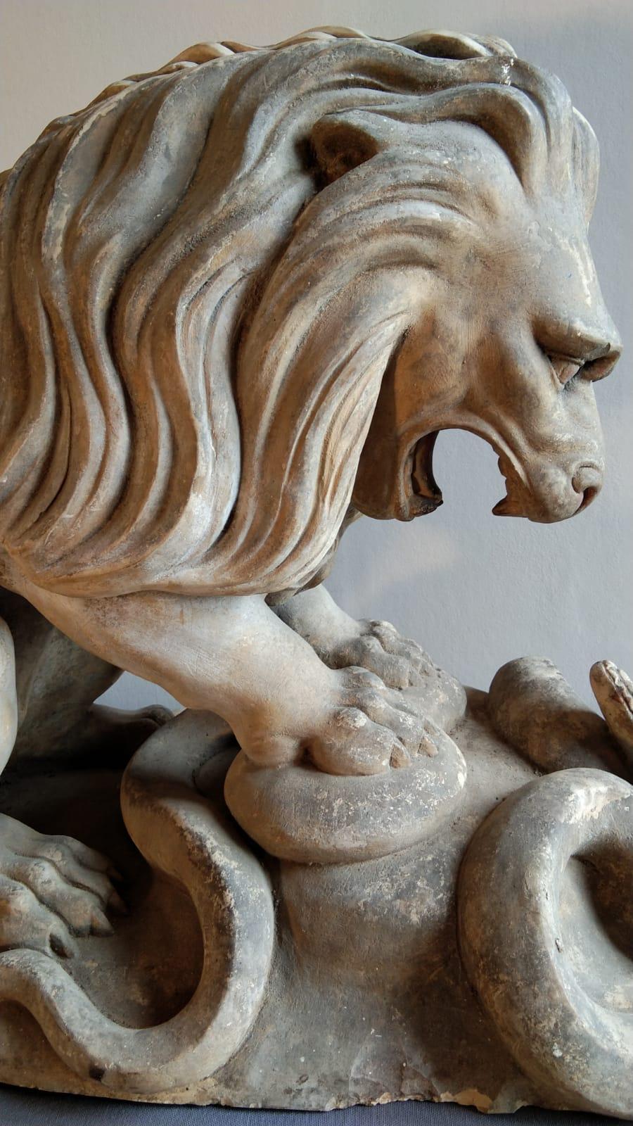 An elegant and impressive terracotta lion fighting a snake. The sculpture has a beautiful color and slight patina.
Perfect for indoors and outdoors. 
France, 19th century. Stamped by Joaquim Bardella Hospitalet.
      