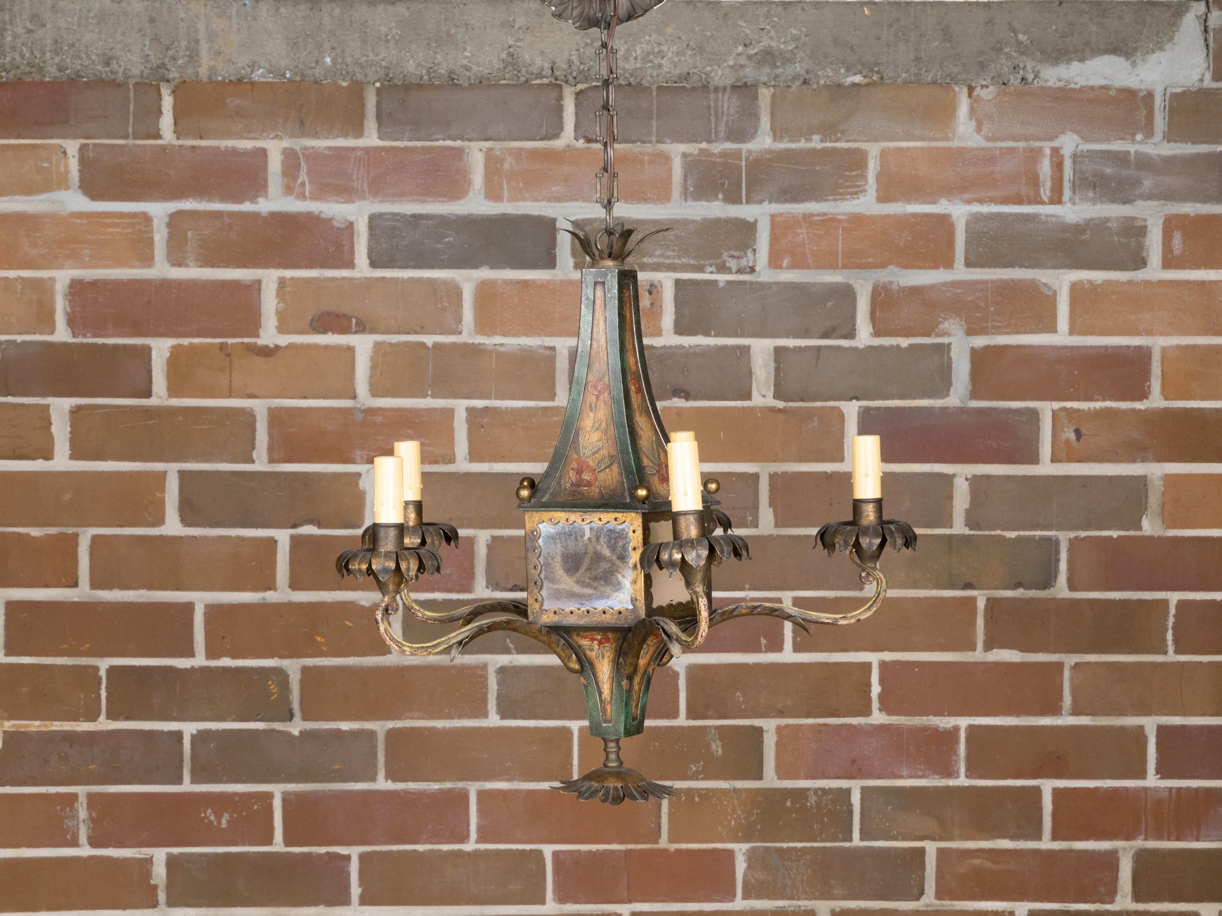 A French tôle five-light chandelier from the 19th century with hand-painted floral décor and antiqued glass panels, professionally rewired for the USA. Charming us with its rustic allure, this French tôle five-light chandelier from the 19th century