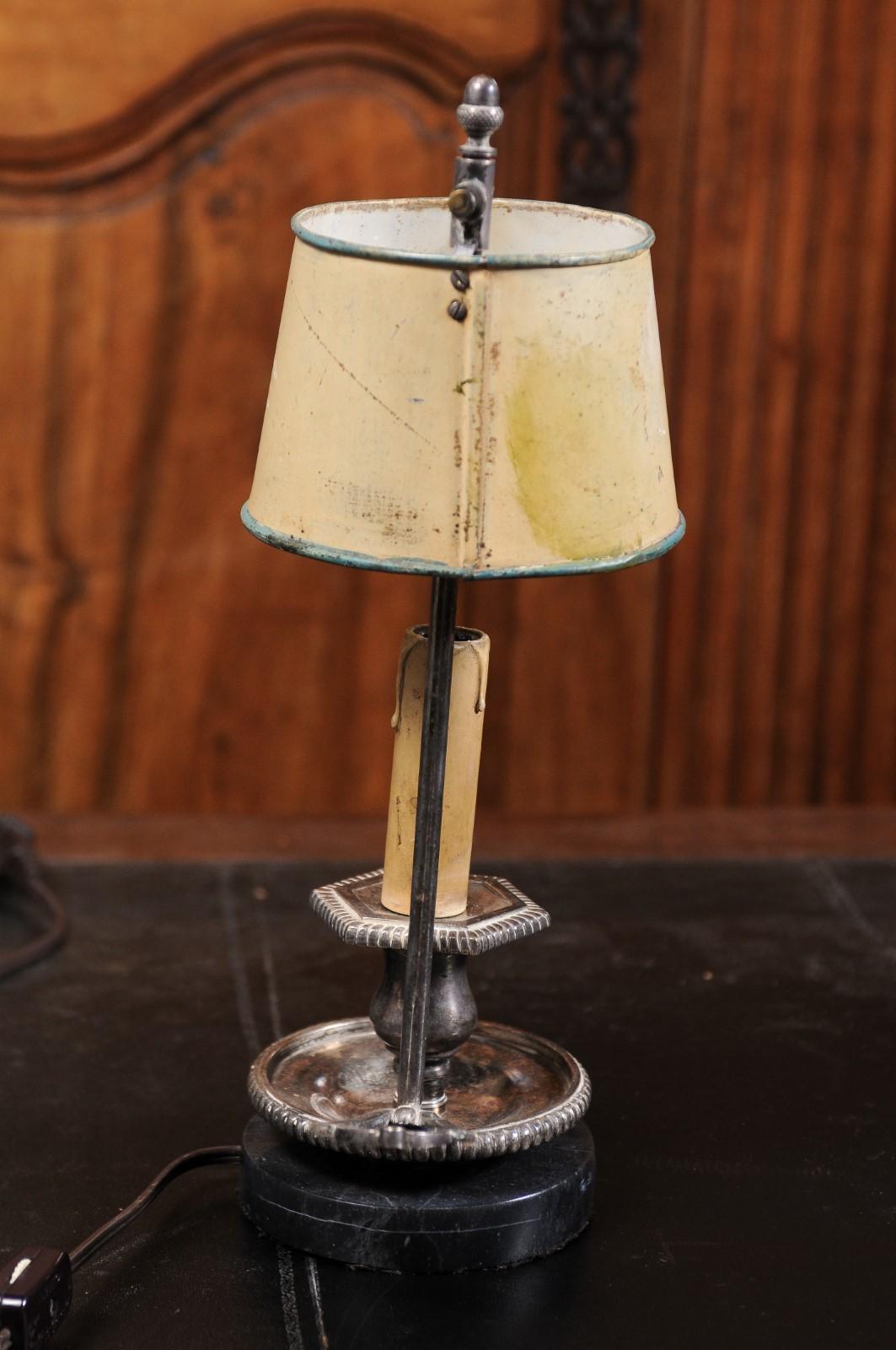 A French tôle lamp from the 19th century, with original hand-painted shade. Created in France during the 19th century, this tôle lamp features its original hand-painted adjustable shade adorned with a ribbon-tied bouquet, protecting a single light.