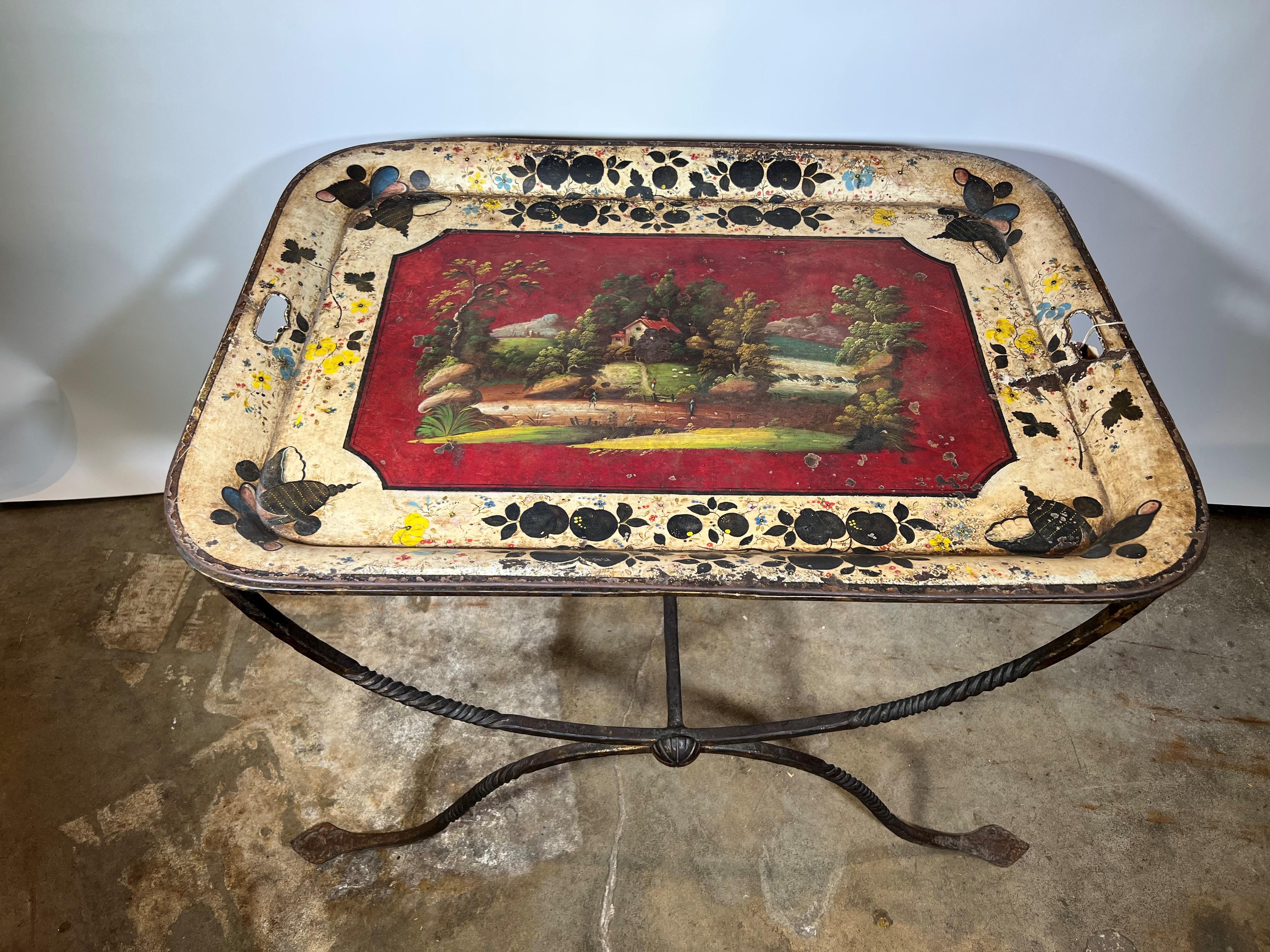 A delightful French side table composed of a very handsome wrought iron base with the removable polychromed tole tray top. I terrific accent piece giving a pop of color.
