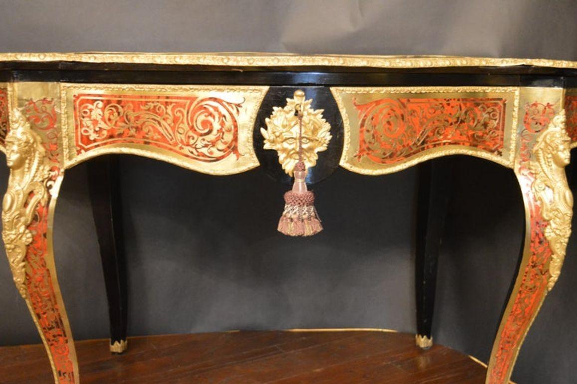 This beautiful French table from the 19th Century is curved with an oval shape. Inlaid with marquetry to the top, edges and along the legs. The table is made of ebonized wood featuring gilt bronze mounts. The legs are of cabriole form and feature