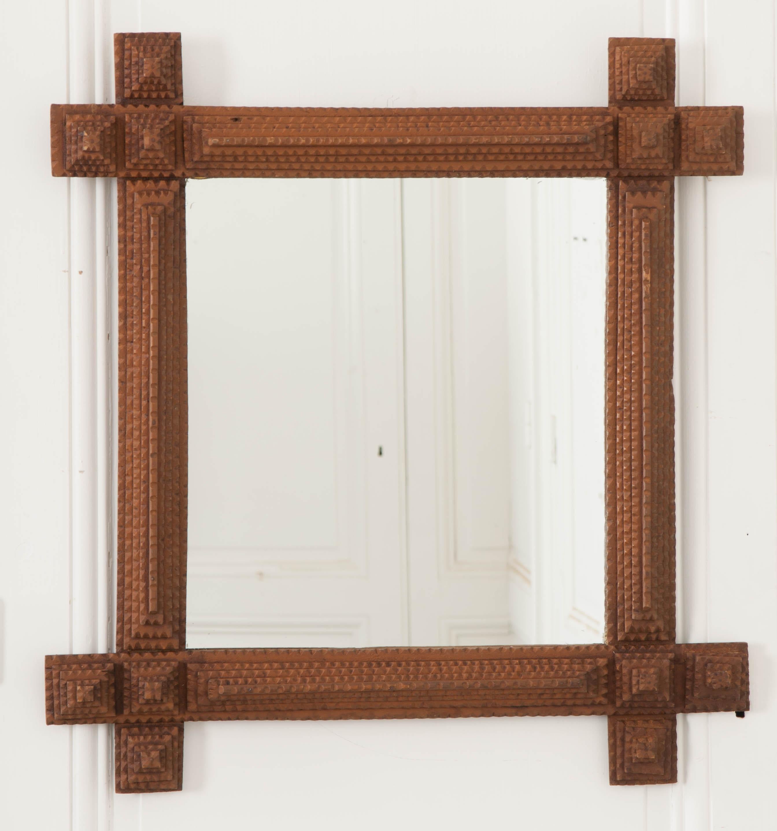 French, 19th century tramp art frame used and sold by travelers and artisans adds history and style to your interior. They are typically made of hardwood frames, simple in design, and decorated with notched pegs. The mirror glass is new.