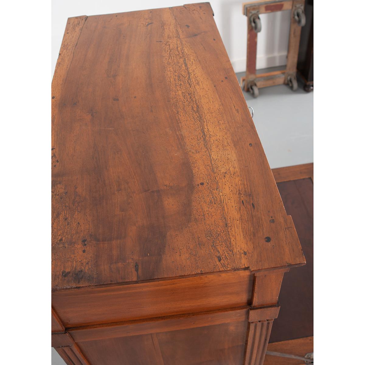 A wonderful mahogany desk with a wood top. The hardware and escutcheons are mixed adding a playful whimsy to this cased piece. A single drawer can be found at the top of the desk that has two oval brass drop-ring pulls. The front of the desk folds