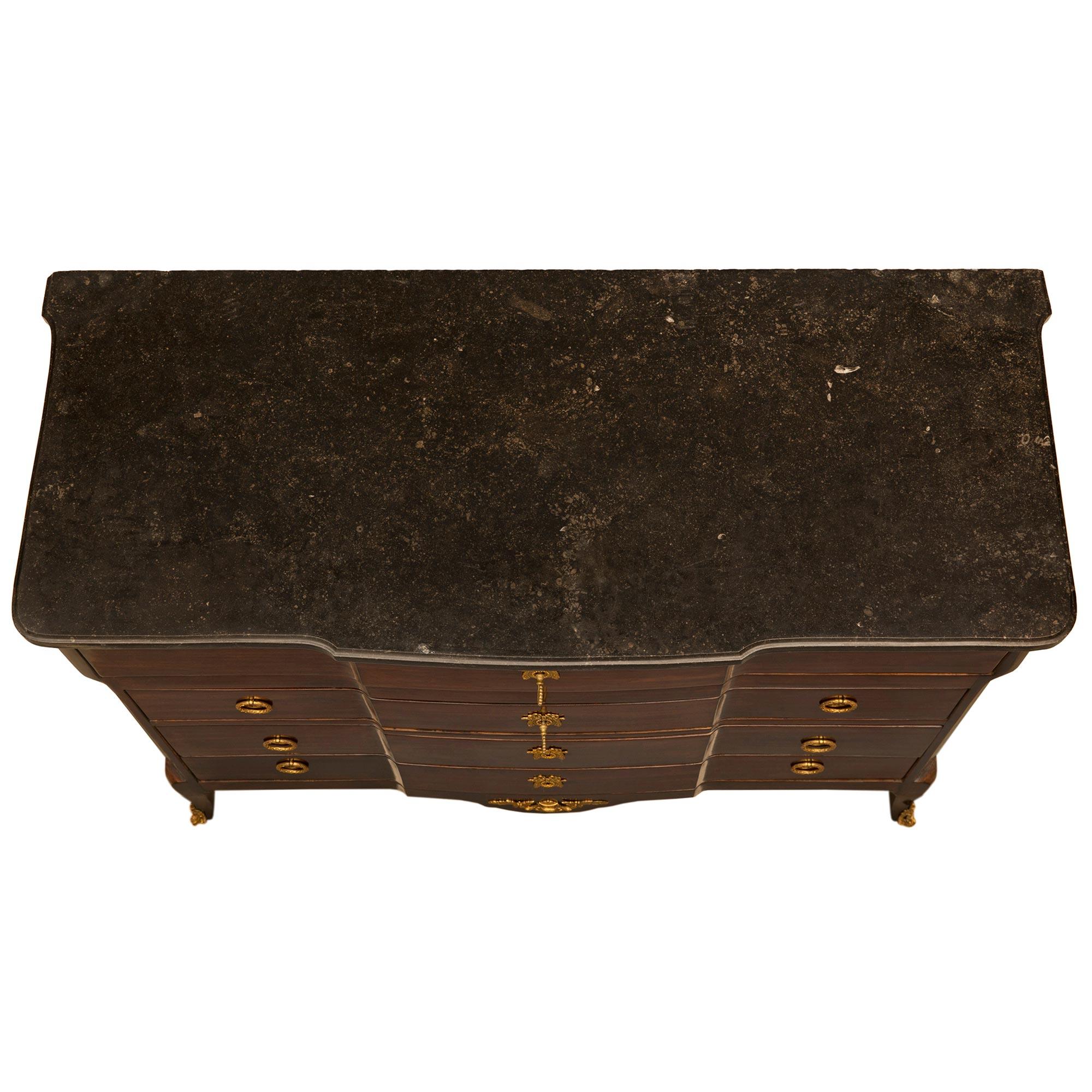 Un bellissimo mobile/segreteria in mogano di stile transitorio francese della metà del XIX secolo. Il mobile è dotato di tutta la ferramenta originale e il piano in marmo è sollevato da gambe cabriole, tutte al di sotto di quattro cassetti. Il