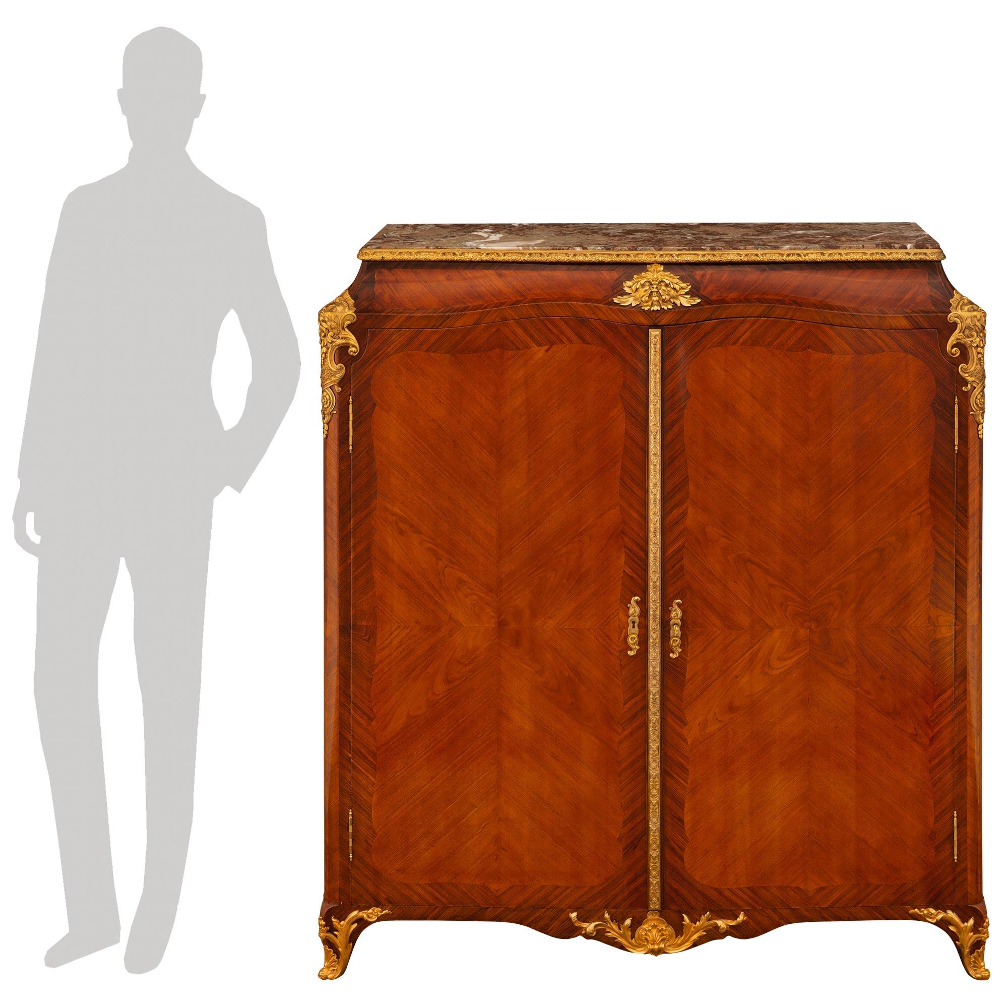 Un mobile di transizione francese del XIX secolo, bello e di alta qualità. Tulipano, Kingwood, Ormolu e mobile in marmo Rouge Royale. Questo splendido mobile a due ante è sollevato da sabot in Ormolu a volute riccamente decorate che fiancheggiano il