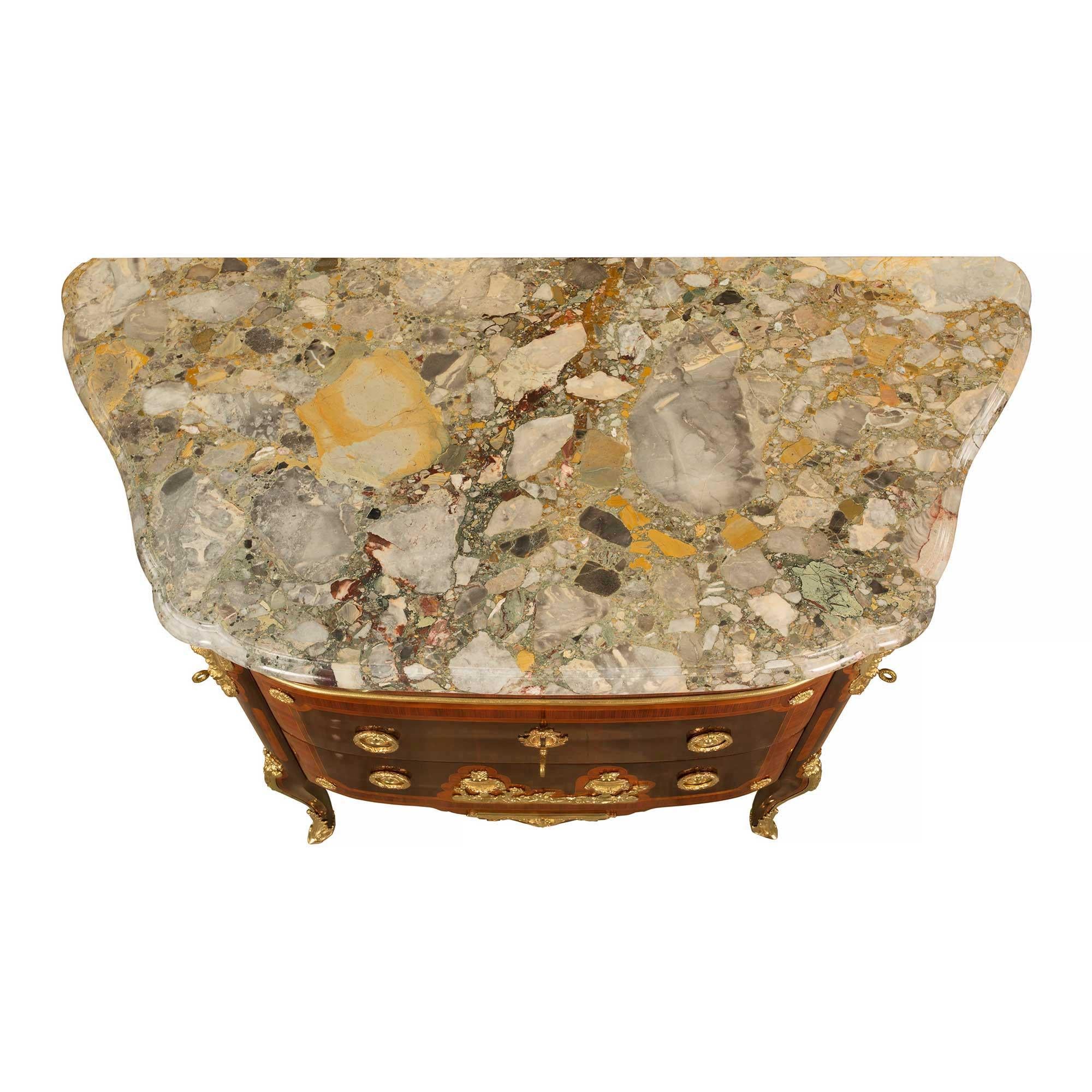 Splendida commode francese del XIX secolo in stile transitorio in mogano, kingwood, ormolu e marmo a tre cassetti e due ante, firmata KRIEGER. La cassapanca è sollevata da elegantissime gambe cabriole con raffinati sabot foliati in ormù e un