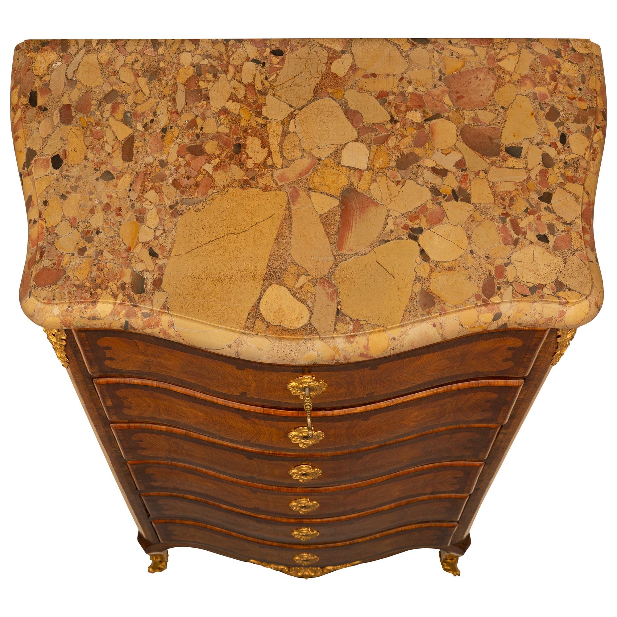Un elegante Chiffoniere a sei cassetti in legno di St. kingwood e ormolu del XIX secolo. Alzato su gambe cabriole con sabot avvolgenti in ormolu finemente traforati. Il fregio a forma di arbusto è centrato da una montatura in conchiglia ormolu
