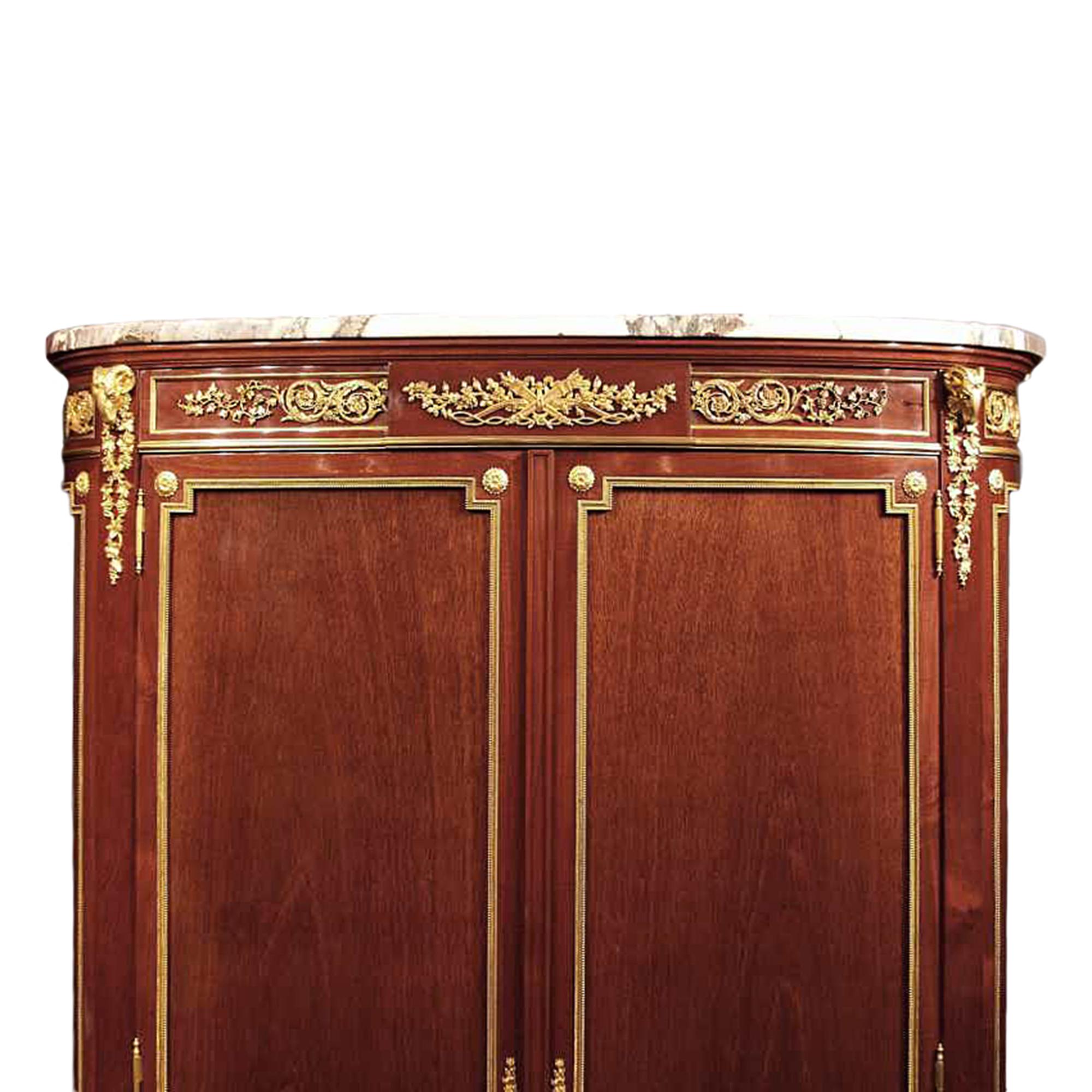 A stunning and extremely high quality French 19th century Transitional st. two door mahogany and ormolu armoire signed F. Linke. The armoire is raised on cabriole legs with ormolu sabots, chutes and top ormolu mounts. The paneled sides and doors