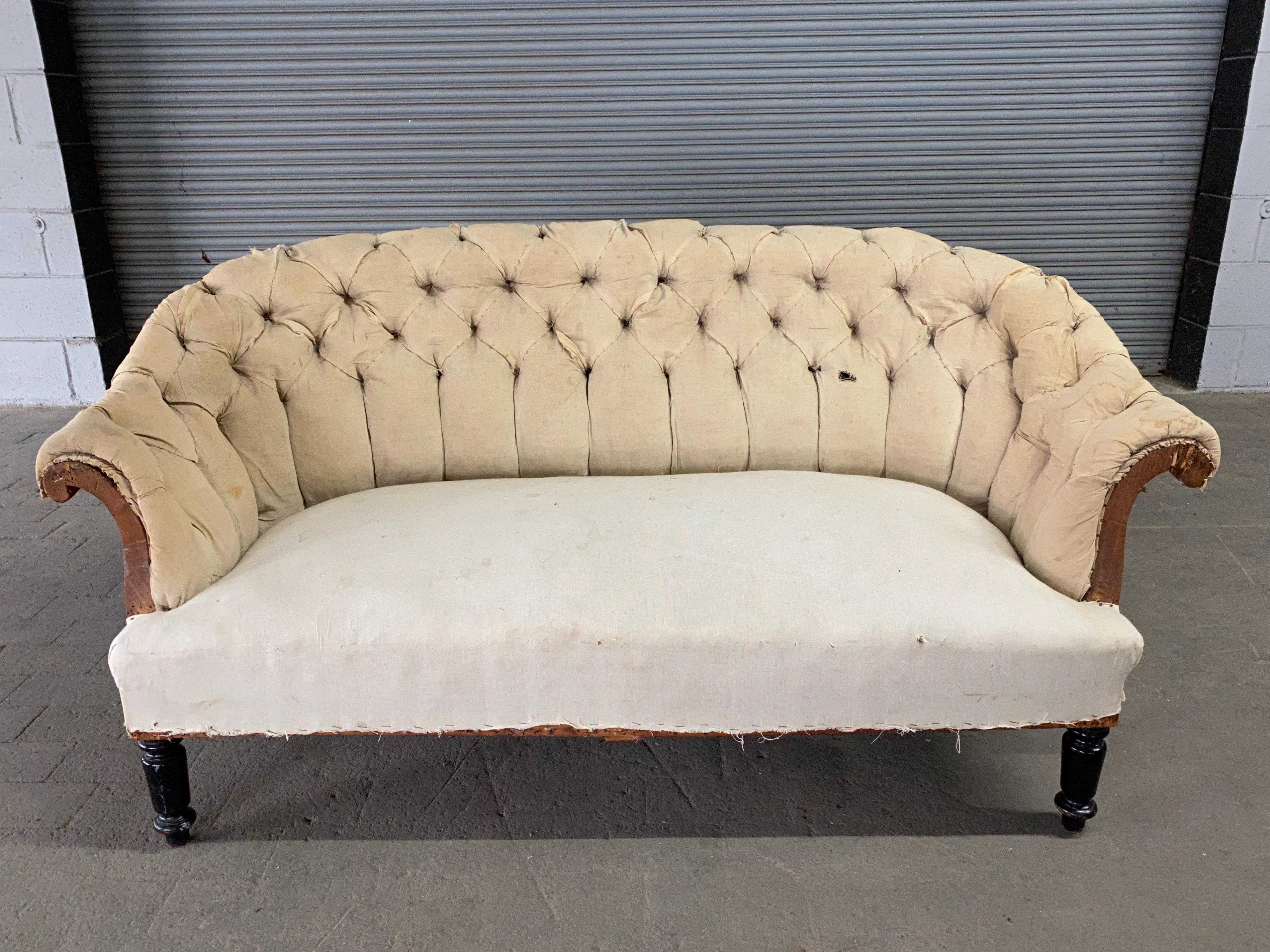 A French 19th century Napoleon III style tufted sofa with rolled arms and back with ebonized legs. The sofa has been stripped down to the muslin and is ready to be upholstered. Sold as is.
 
 