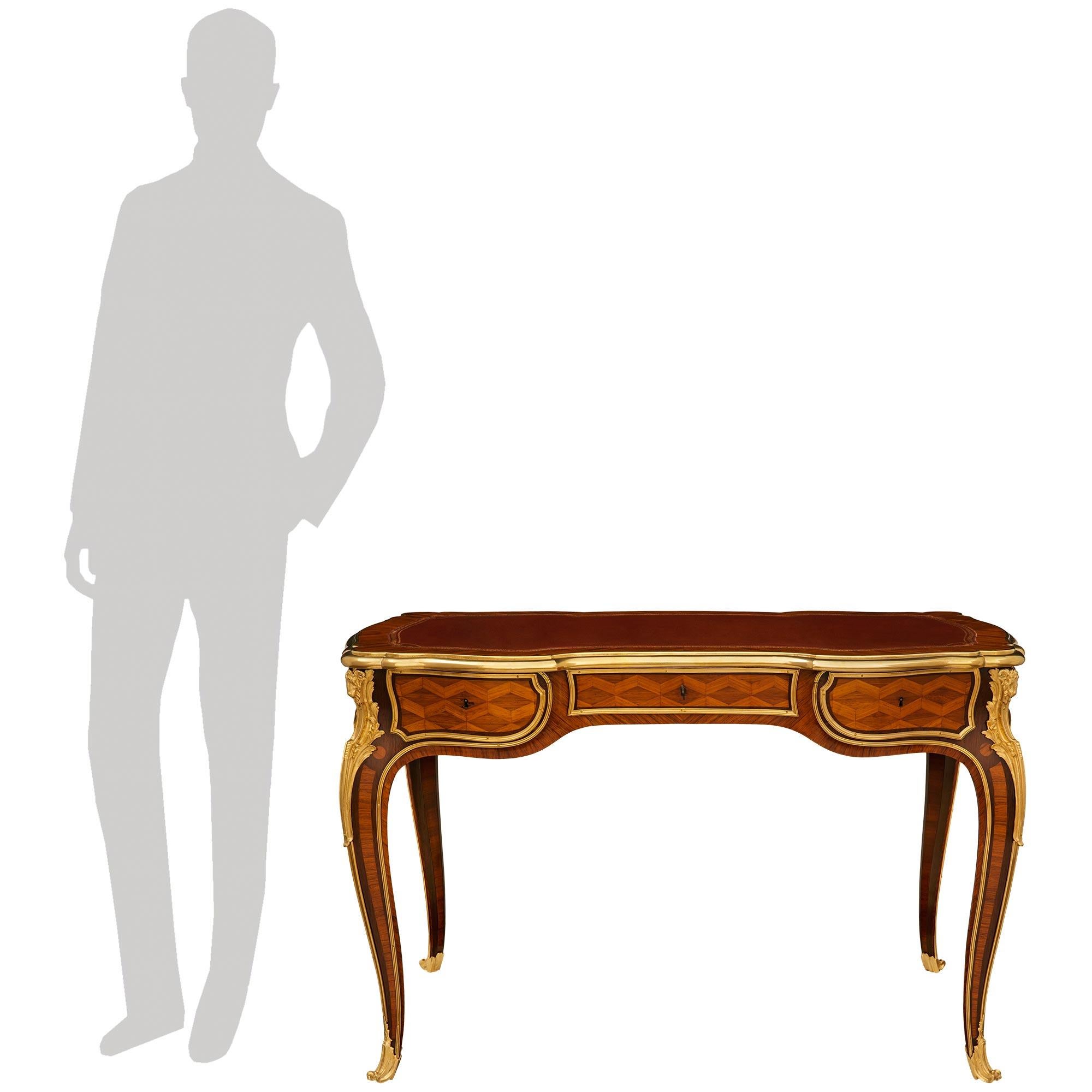 Scrivania francese del XIX secolo in legno di tulipano, legno di re e ormeggio, attribuita a Durand, di alta qualità. Questo eccezionale Bureau Plat è sollevato da quattro gambe cabriole elegantemente intarsiate, riccamente decorate da scivoli