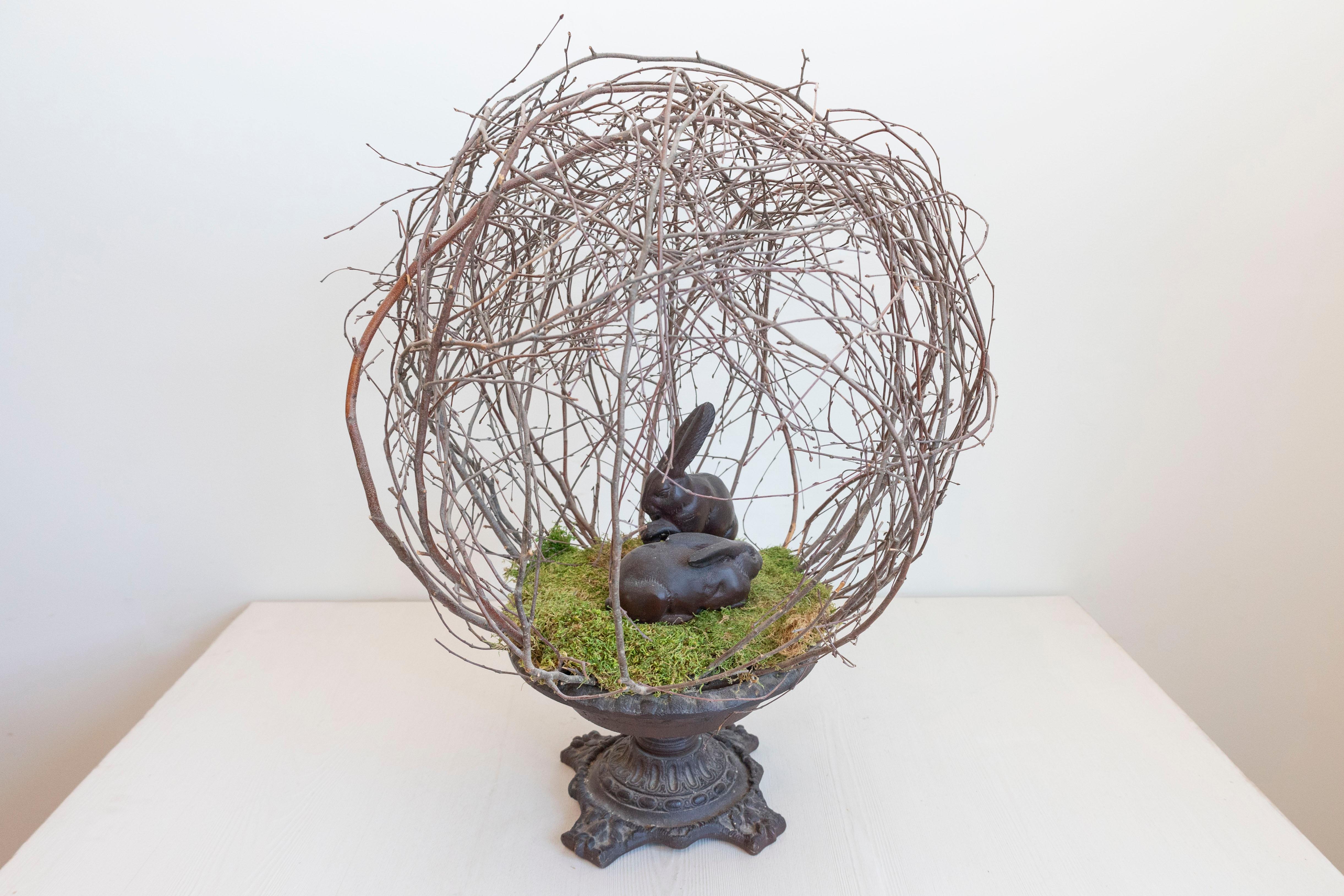 Scultura rustica francese con ramoscello e coniglietto del XIX secolo, con base in ferro. Creata in Francia nel XIX secolo, questa scultura attira la nostra attenzione con la sua disposizione circolare di ramoscelli che circondano due coniglietti