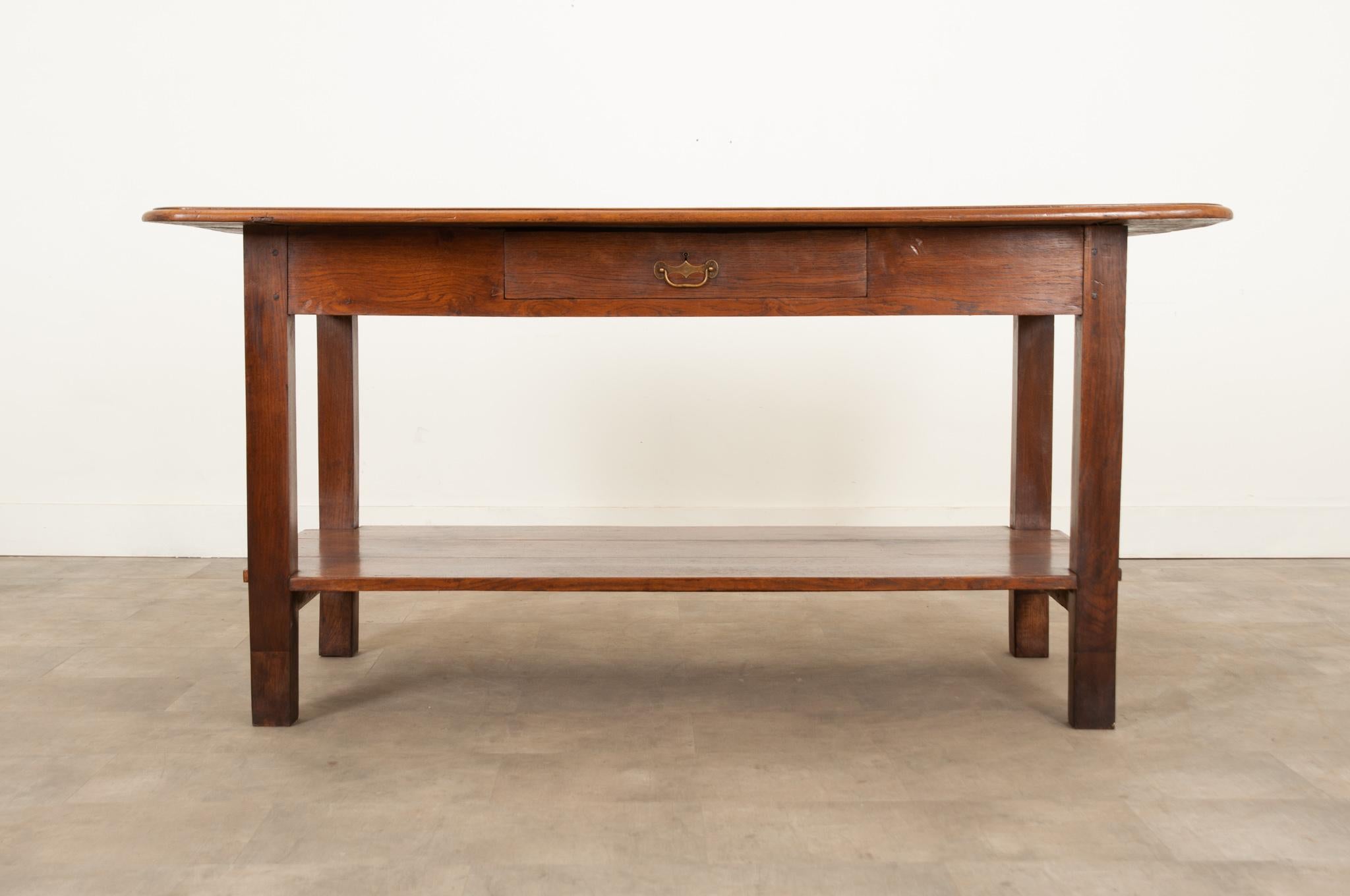 This stunning French 19th century work table from Burgundy with its thick oak top and legs that have been raised to standing height, would make a gorgeous kitchen island. Crafted from solid walnut and oak, it remains incredibly sturdy and level.