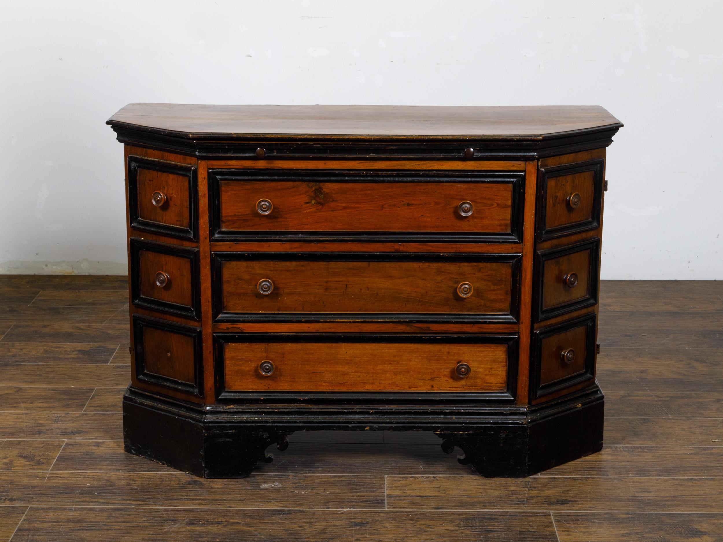 A French two-toned walnut dresser from the 19th century with canted sides, three drawers, two doors and ebonized accents. This French two-toned walnut dresser from the 19th century elegantly combines functionality with ornate design, making it a