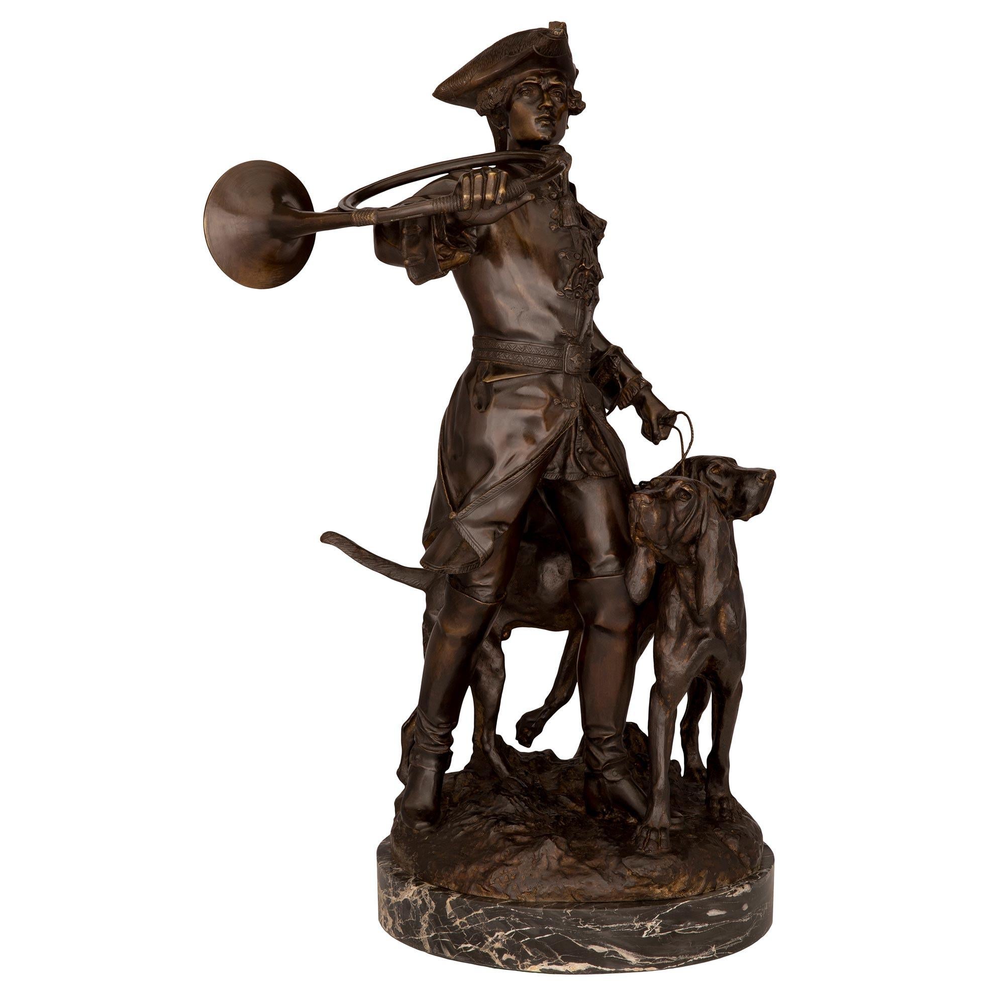 An extremely high-quality French 19th century Verdigris signed bronze statue. The statuary is raised by a circular mottled base with a wonderfully executed ground-like design where the hunter and his two dogs stand. The hunter is dressed in