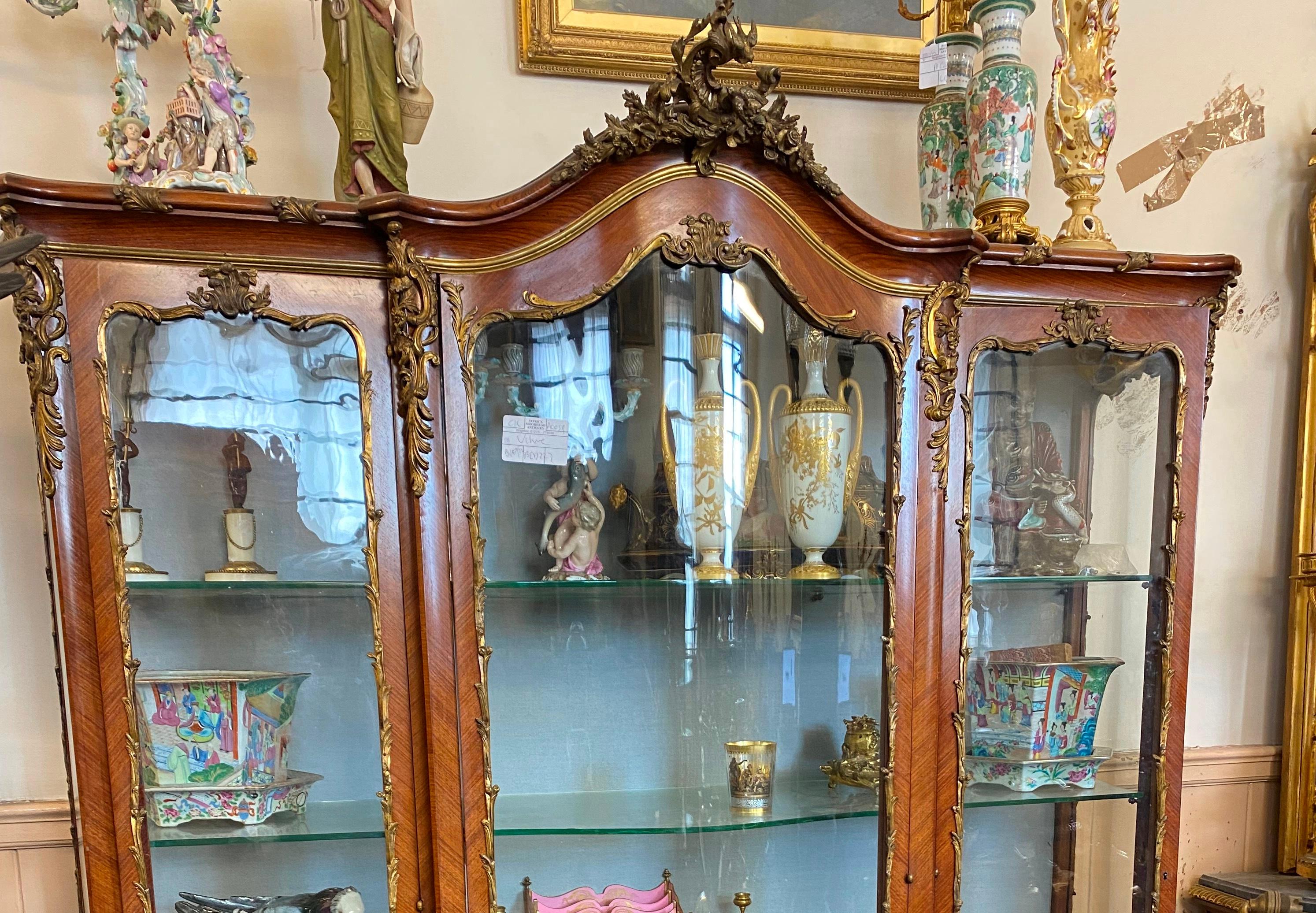 Vitrina francesa de estilo Luis XVI de finales del siglo XIX de muy buena calidad, con tres puertas en la parte delantera que se abren para dejar ver estantes ajustables en el interior. Maravillosa decoración de marquetería floral incrustada en la
