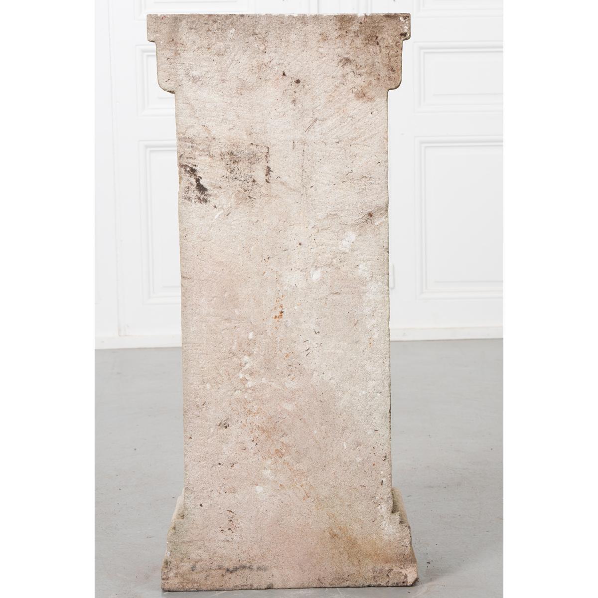The is an unusual European wall pedestal or console. It is made of reconstituted stone with a flat surface at the top. A large scroll goes from top to bottom and rests on a rectangular base. This piece would be great indoors or out. 
 