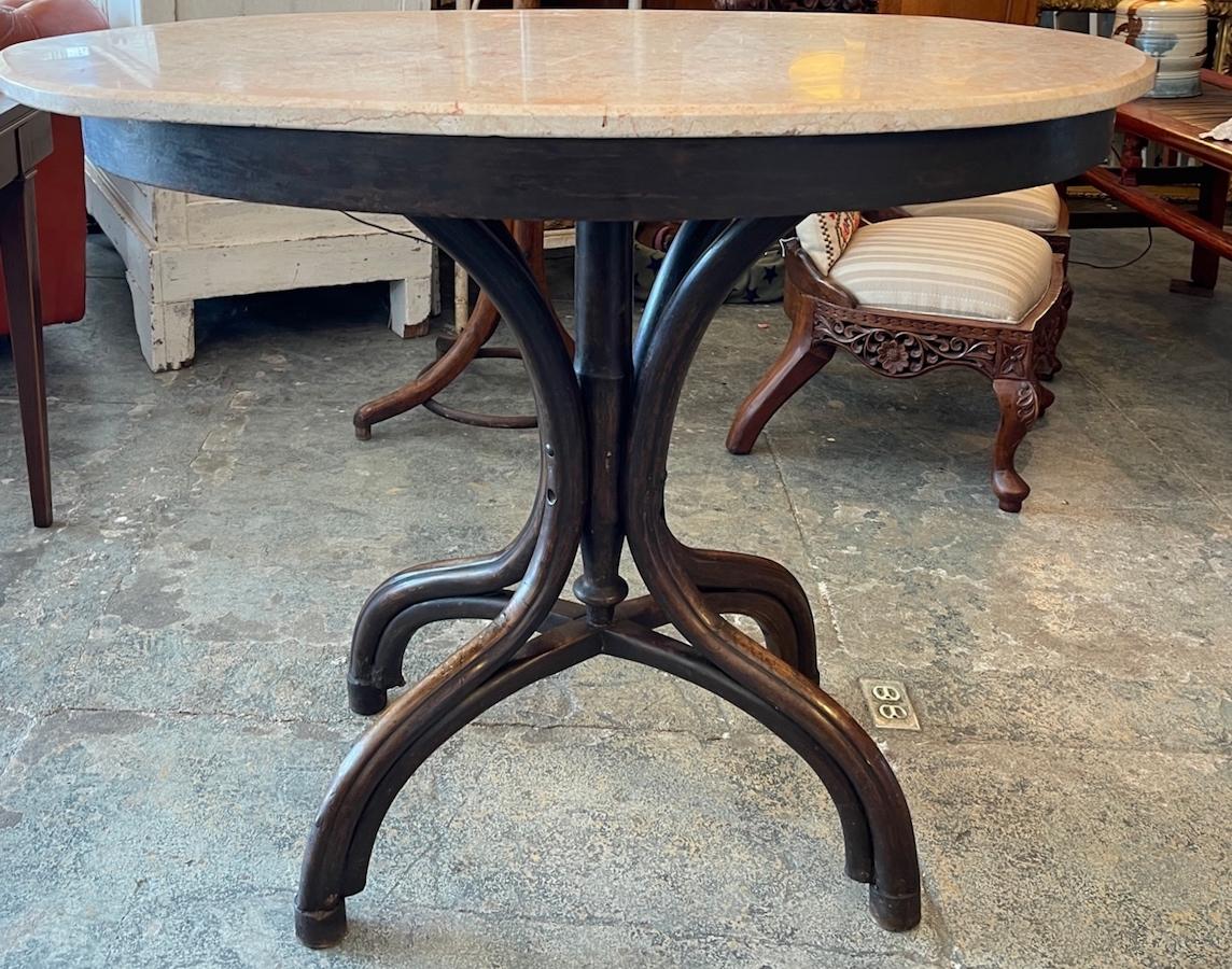 This is an unusual 19th century French cocktail table with and oblong or oval marble top. The table stands on a four leg pedestal of stained walnut.