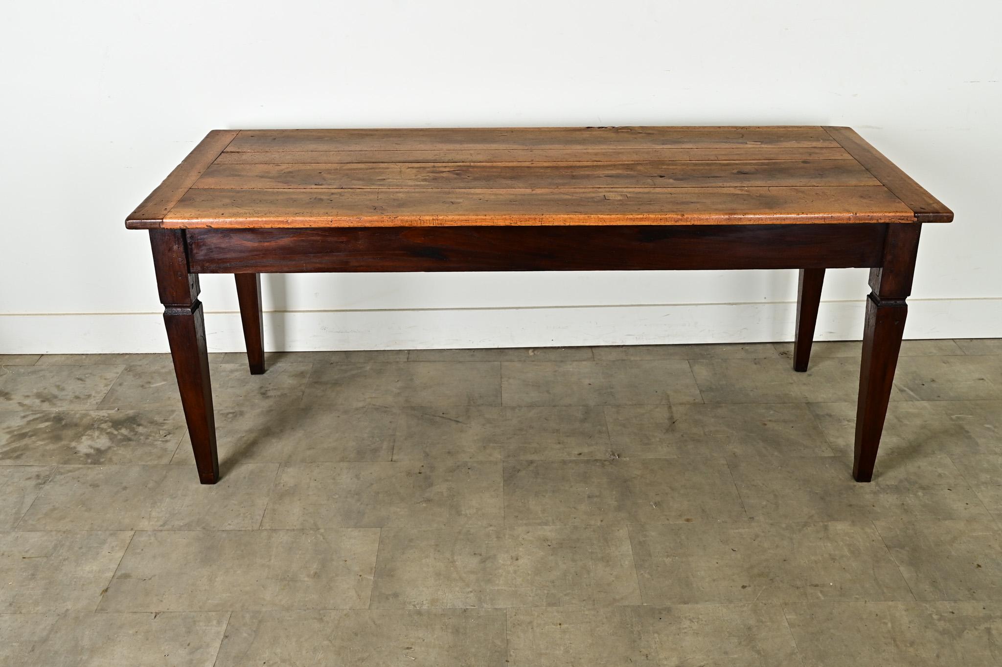 This rustic farmhouse dining table from France, late 19th century, is made of walnut, naturally beautiful and well patinated: the planks are dotted with layers of patina and finished with breadboard ends. The apron and base are crafted of oak,