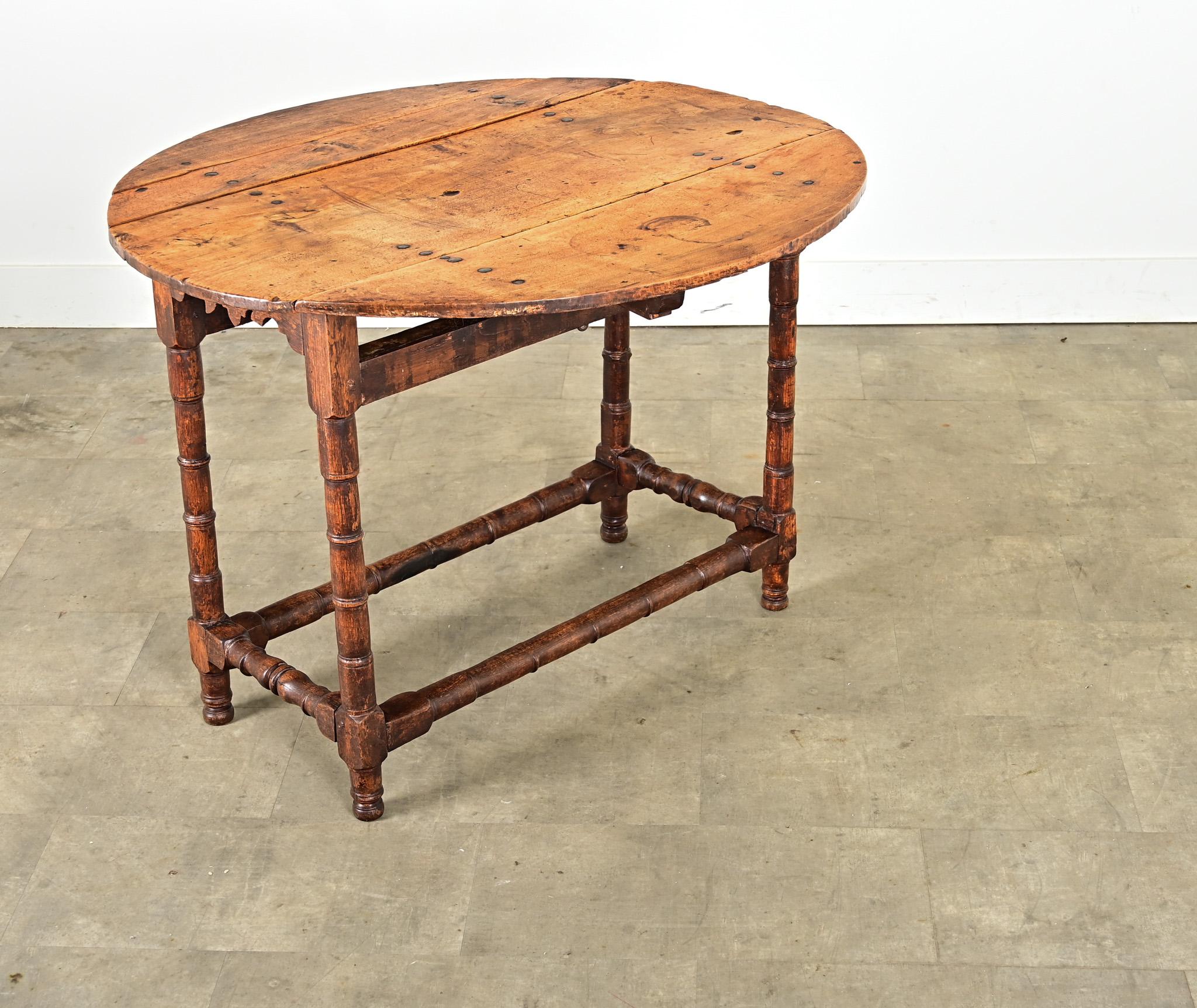 Magnifique console en noyer et chêne patiné, fabriquée en France au XIXe siècle, facilement transformable en petite table de salle à manger ou de centre selon les besoins. Les planches supérieures sont ponctuées de gros goujons en fer pour boulonner