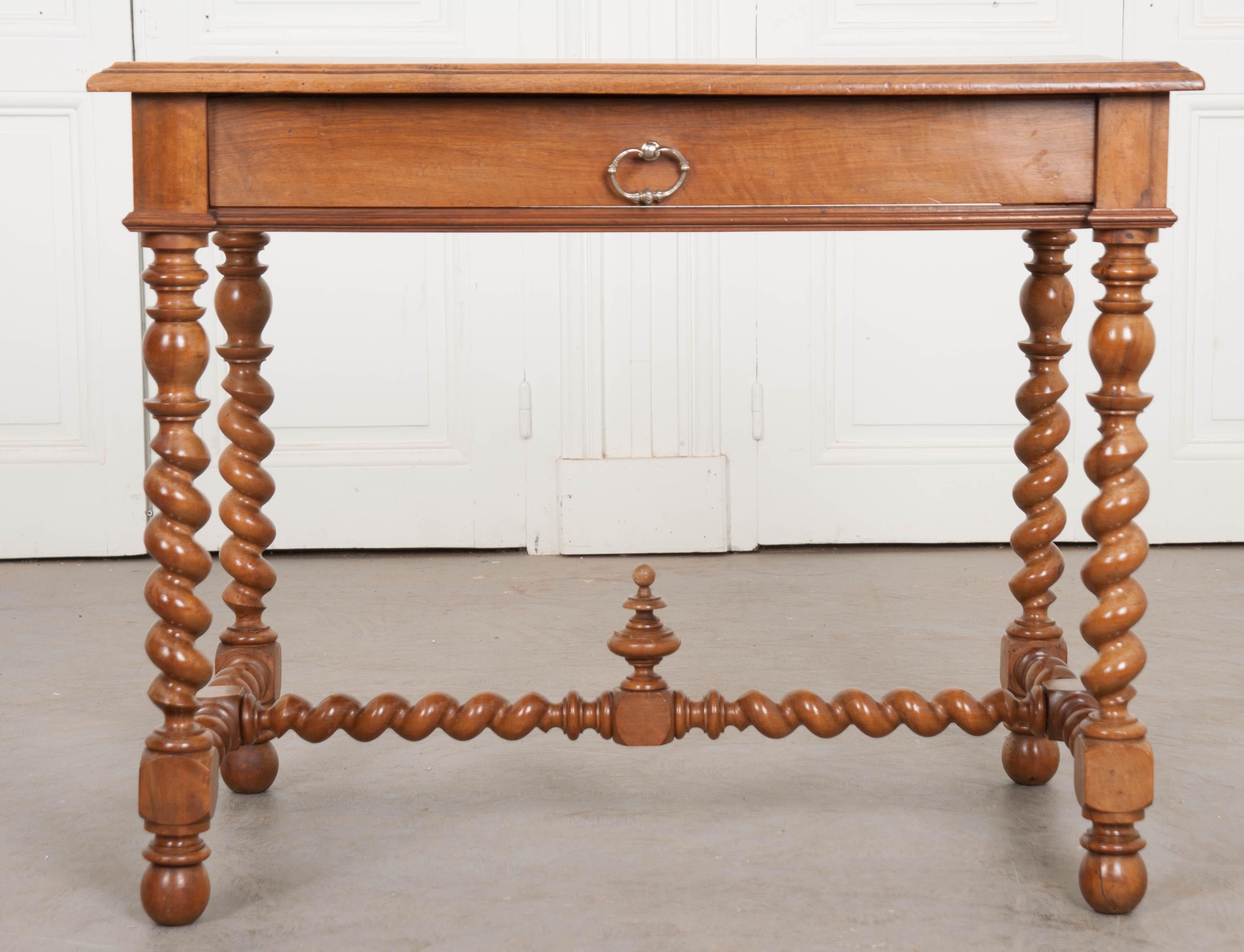 A fine French writing table, or desk, made of beautiful solid walnut, circa 1870. Four impeccably well-turned legs steal the show along with the table’s twisted stretcher. The legs and stretcher have been created in a barley twist design and meet at