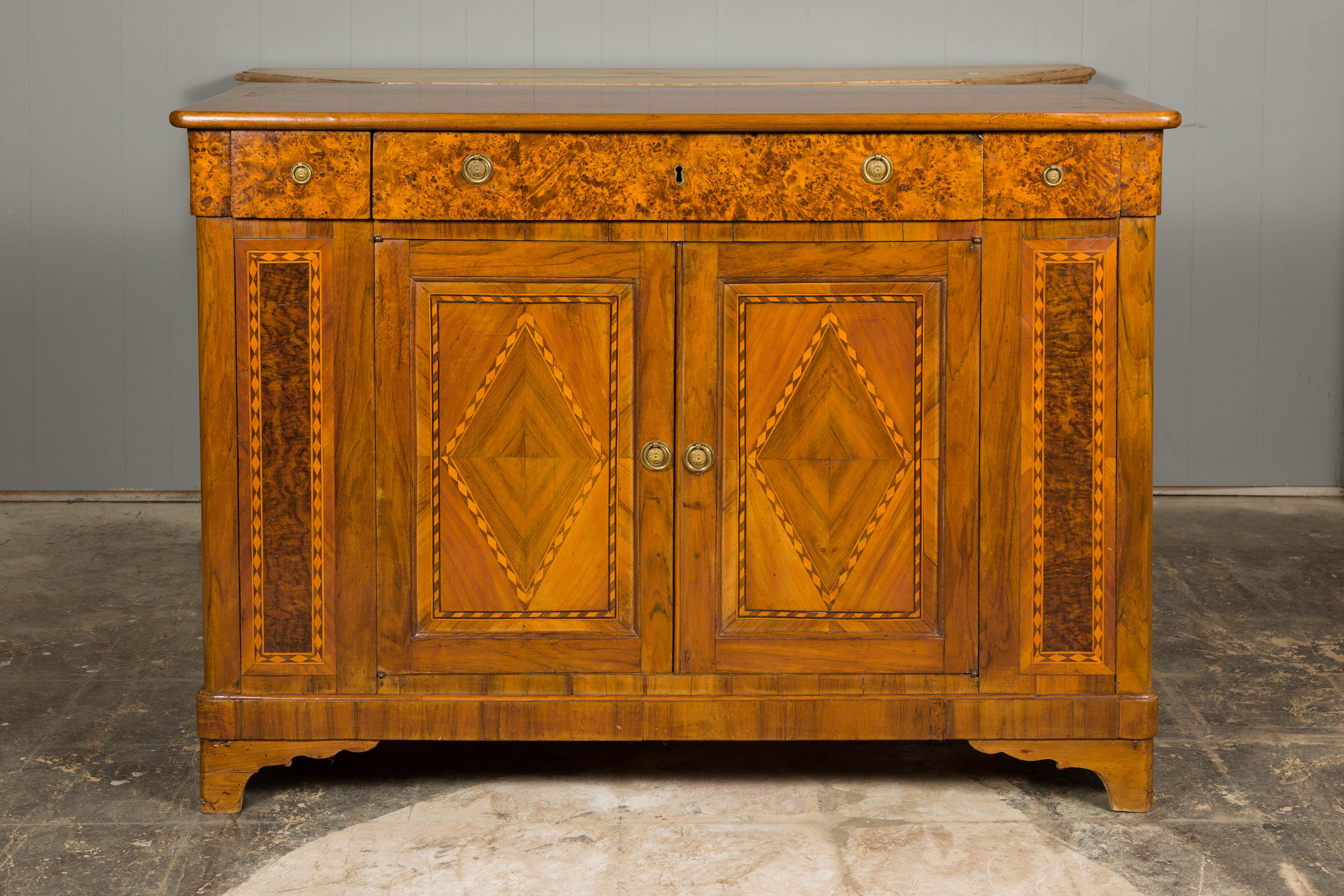 A French walnut buffet from the 19th century with burled accents, doors inlaid with diamond motifs and ogee bracket feet. Embrace the exquisite charm of this French 19th-century walnut buffet, a masterpiece of craftsmanship that marries function