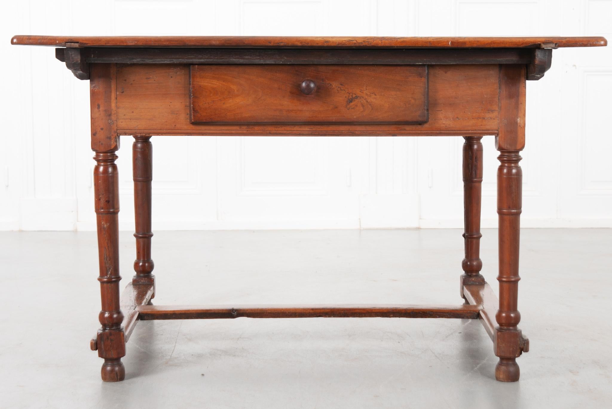 This is a nice French 19th century center table – constructed of walnut. The table’s apron has a large single drawer that can be opened with a wooden pull. It has four turned legs that are braced by a H-form stretcher below.