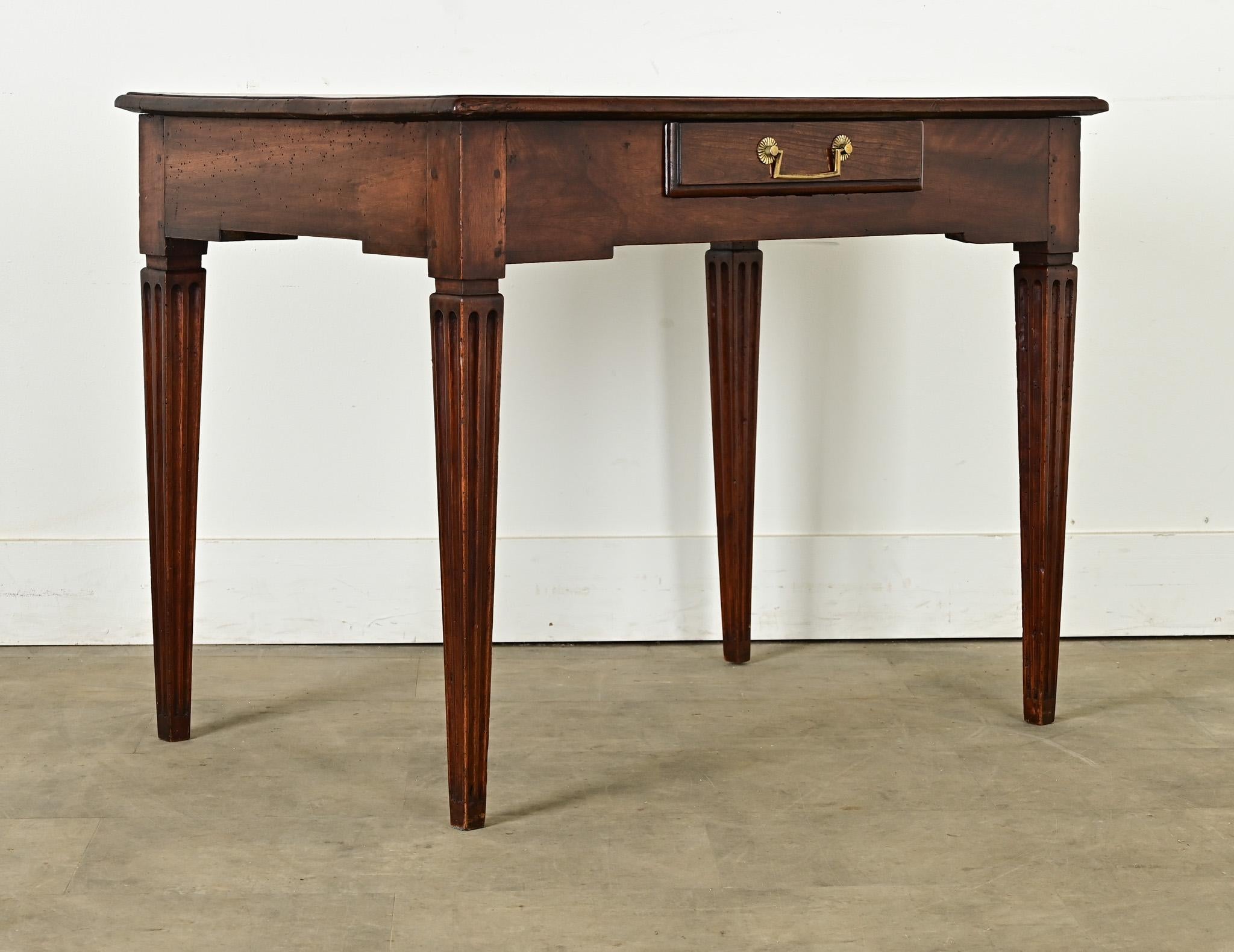 Petite, French occasional table or desk from circa 1840, of solid walnut. The style is refined and restrained: nearly two centuries of use have left the expected patina on the top surface, which is punctuated by an inlaid square patch from an old