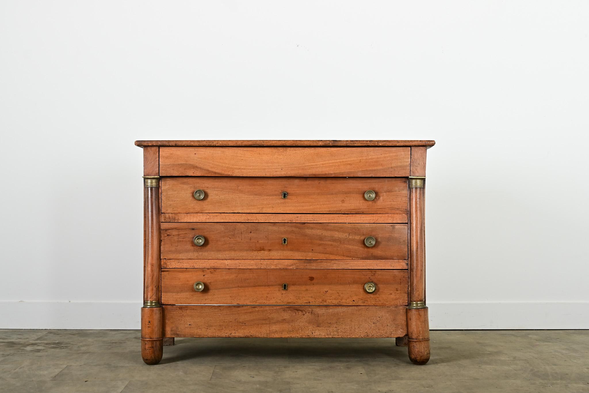 A handsome French Empire walnut commode from the 19th century, circa 1850. The top planks still bear the low ridges across the grain from being cut and milled by hand nearly two centuries ago, enhanced by patina developed in that time. The