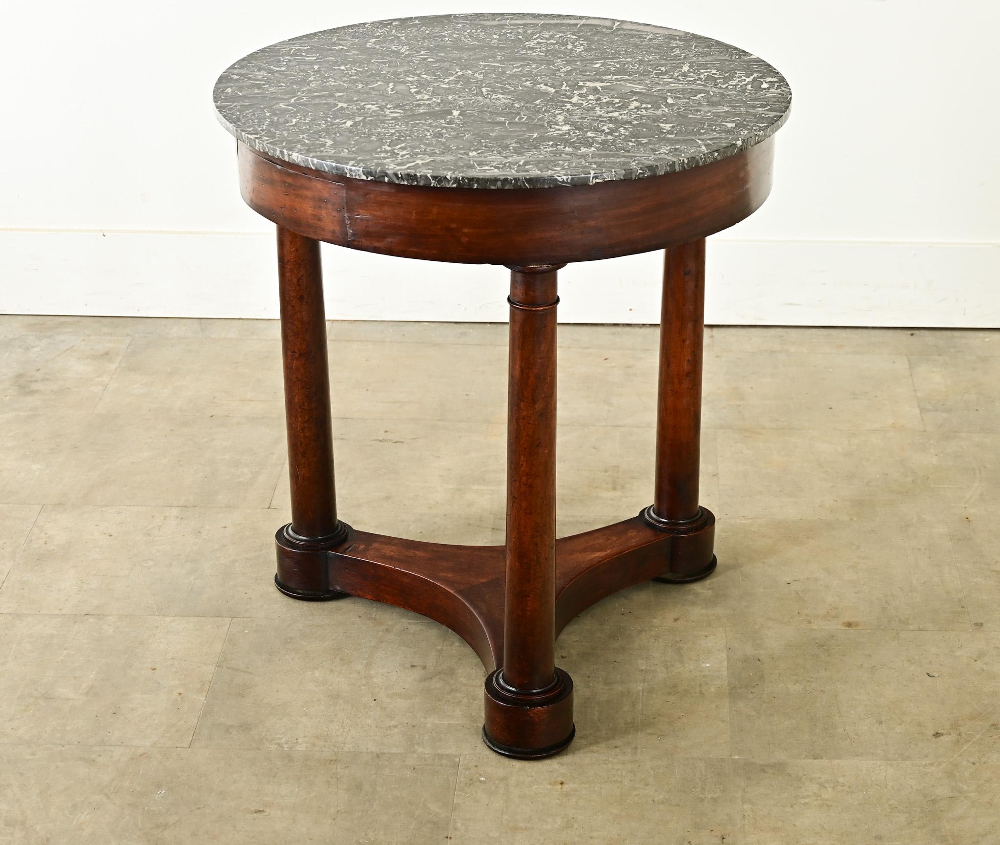 Terrific 19th Century French Empire gueridon table. The flat, St. Anne marble top is removable from the base, resting on three columnar legs that are joined by a concave stretcher below. The apron houses a single drawer which is free of hardware to