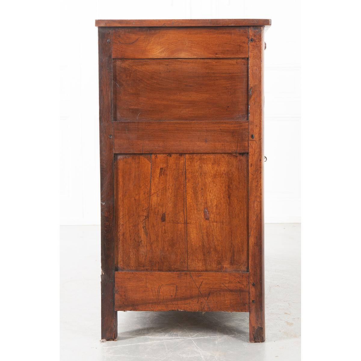 A handsome walnut enfilade, made in France. The case piece has been constructed with simple straight lines. The apron contains three drawers, each with a wood pull. Three paneled doors across the front are equipped with working locks and three keys.