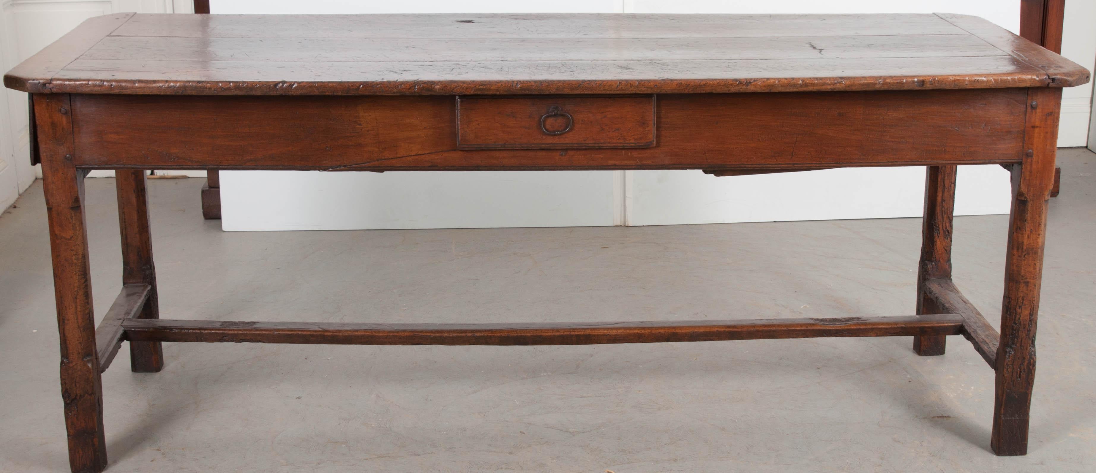 A spectacularly aged walnut farmhouse table from the French countryside, made circa 1830. The table has a marvellous top, is made of three boards, and has canted corners and breadboard ends. Three large drawers reside in the table’s apron, allowing