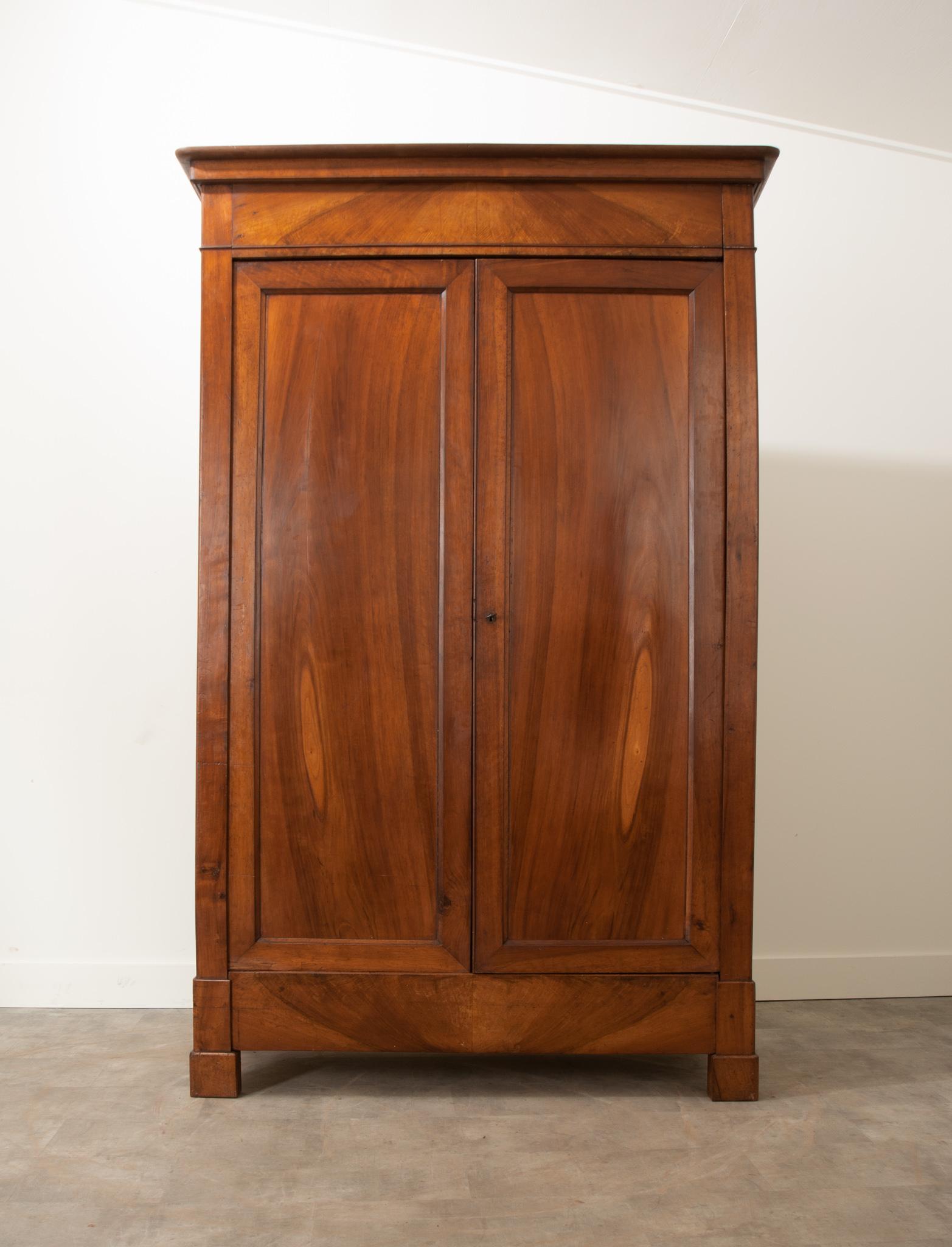 A gorgeous 19th century walnut armoire, made in France in the Louis Philippe style. This tall case antique has a simple, linear composition - an attribute that makes Louis Philippe pieces ideal for their versatility and placement possibilities. They