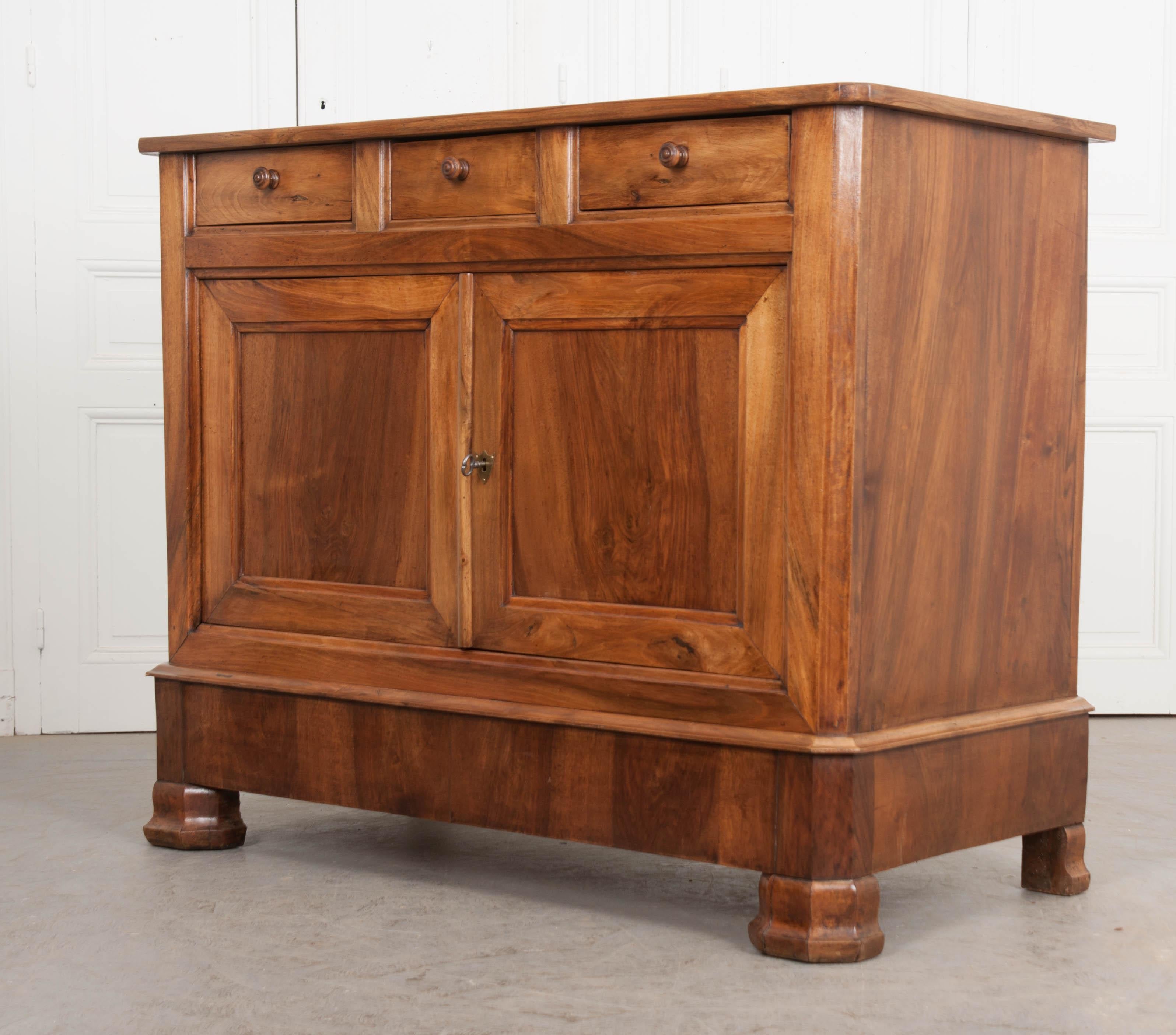 Beautifully-grained walnut was selected when creating this emblematic Louis Philippe buffet in France, circa 1880. The top has canted corners that correspond to those found on the base. Three drawers are located above the buffet’s cavity, all