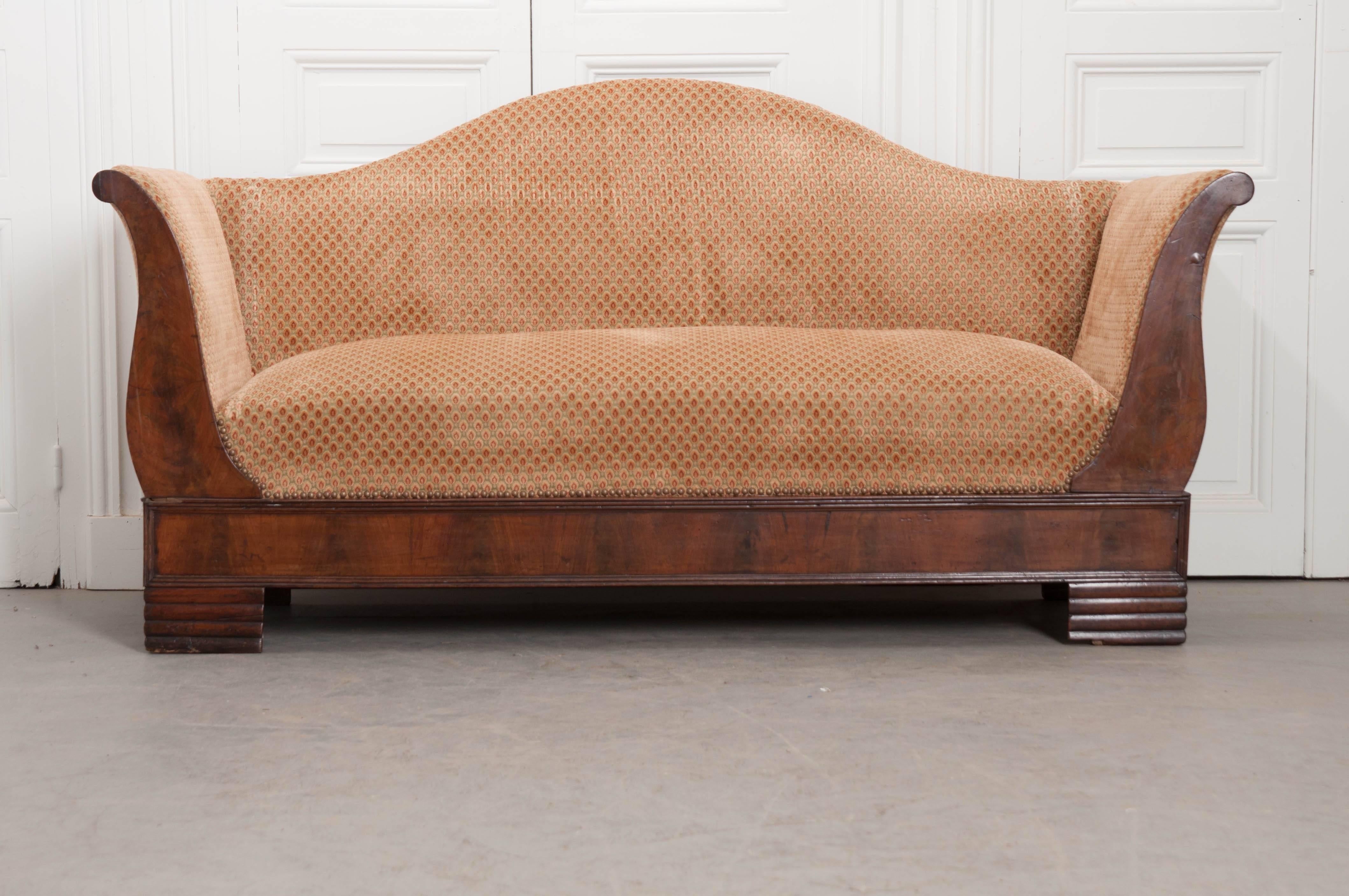 This sensational canapé was made in France, circa 1870. The settee has been made in the Louis Philippe style, with carefully book matched walnut veneer that is stunning. The sofa is upholstered in a patterned cut velvet in colors of sage, gold and