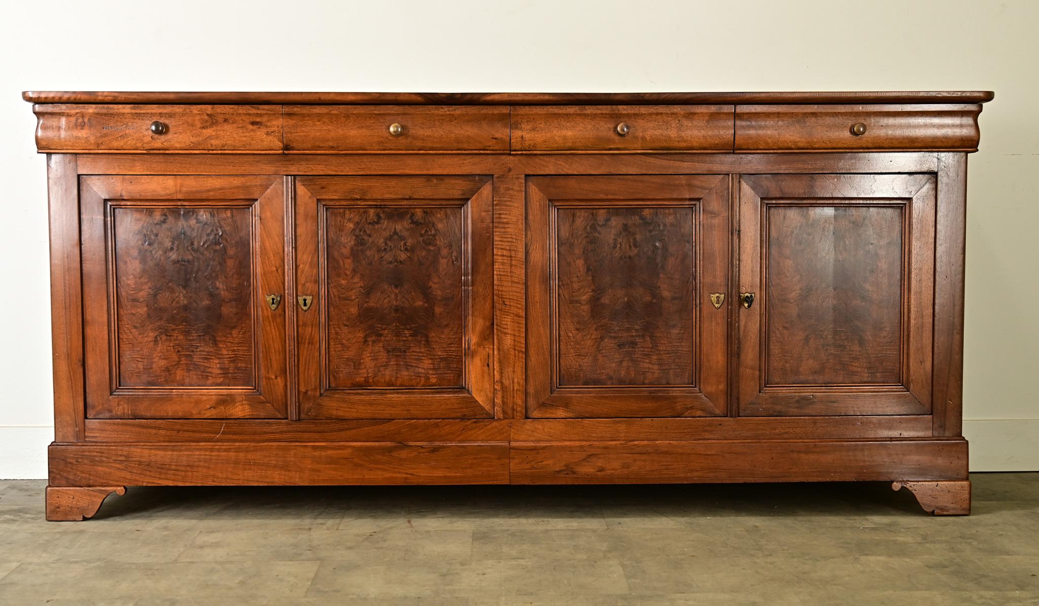 Remarquable enfilade Louis Philippe en noyer, vers 1840, remarquable par ses tons de bois lumineux et son placage de loupe assorti aux livres sur les façades des portes, ainsi que par ses dimensions généreuses qui attirent l'attention dans n'importe