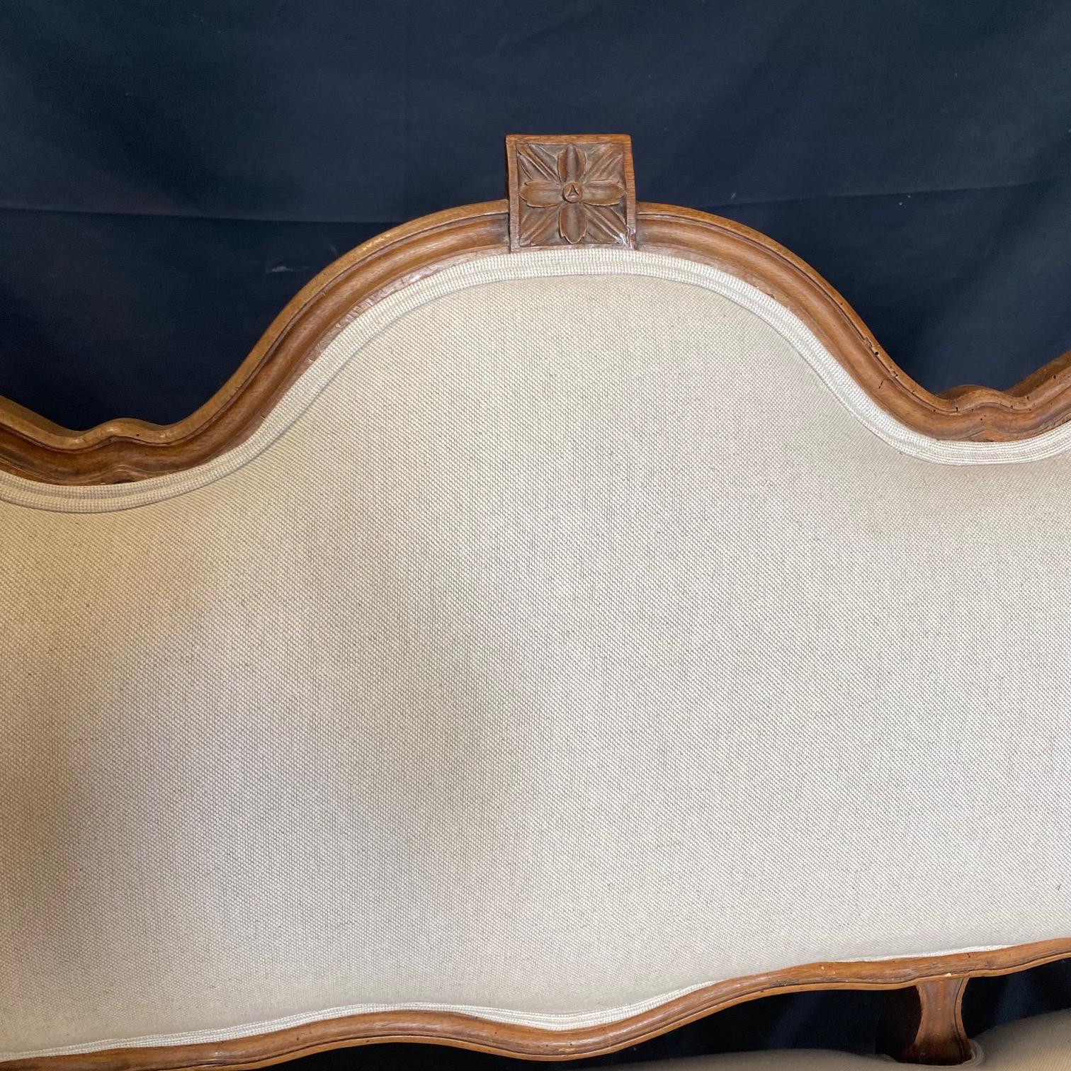 Ein französisches Sofa aus der Zeit Ludwigs XVI. mit provenzalischen Schnitzereien aus dem späten 19. Jahrhundert, mit neuer Polsterung, schönen kannelierten Beinen und exquisiten Schnitzereien. Dieses Sofa aus französischem Nussbaumholz, das in der