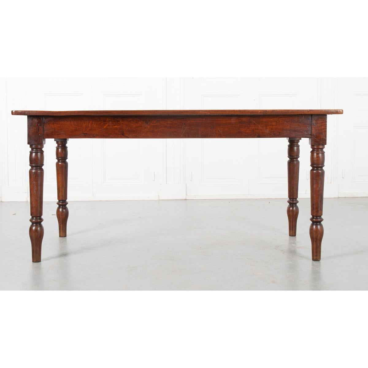 This is a French 19th century farm table made with walnut and oak. The top has a beautiful patina and sits over a plain apron which rests on turned legs. The piece has been cleaned and polished with a French paste wax. Circa 1870.
 