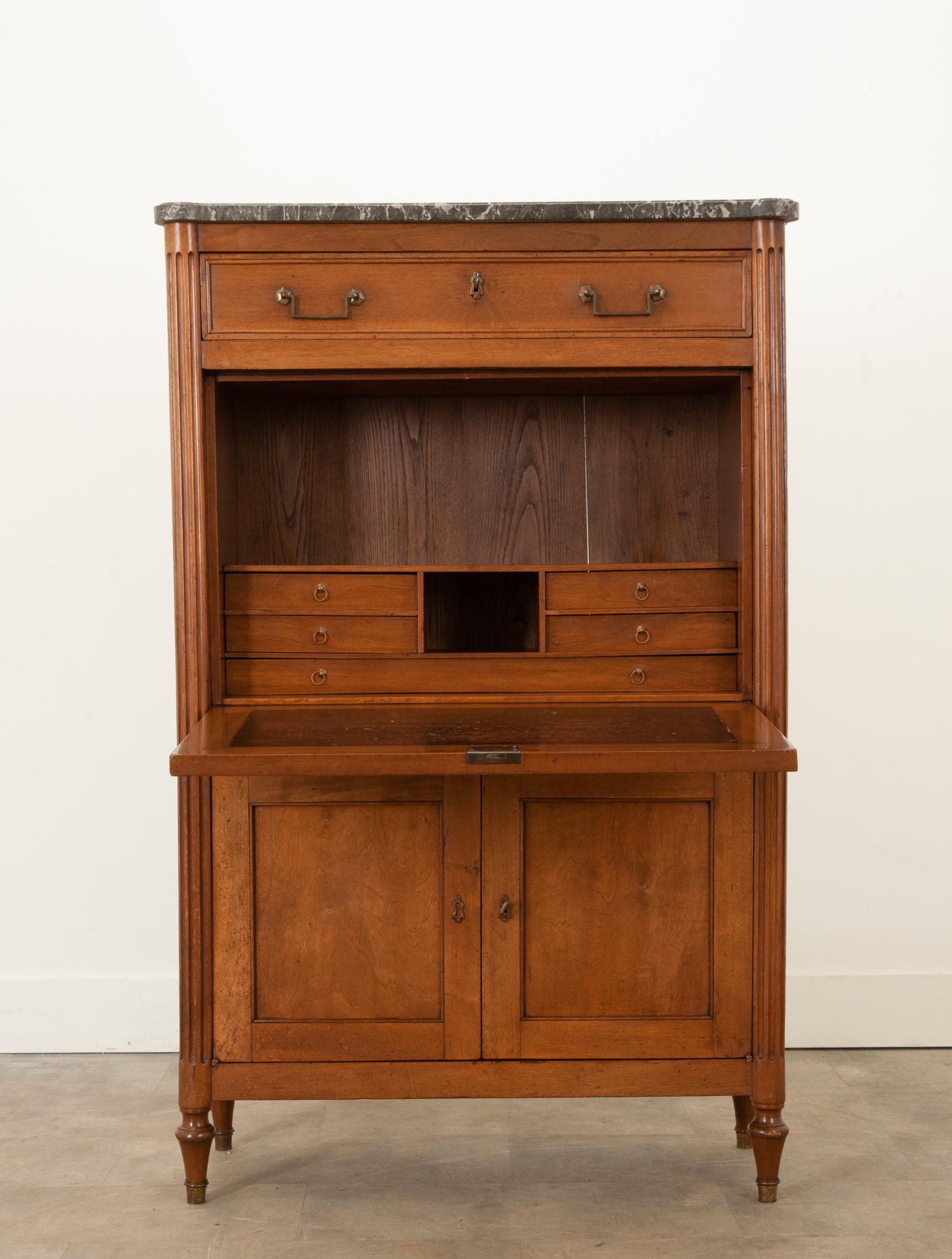 This wonderful walnut secre´taire a` abattant was constructed in the style of Louis XVI during the 19th century. Topped with a great piece of black and white marble. A single, slim drawer at the top features a pair of brass rectangular drop ring