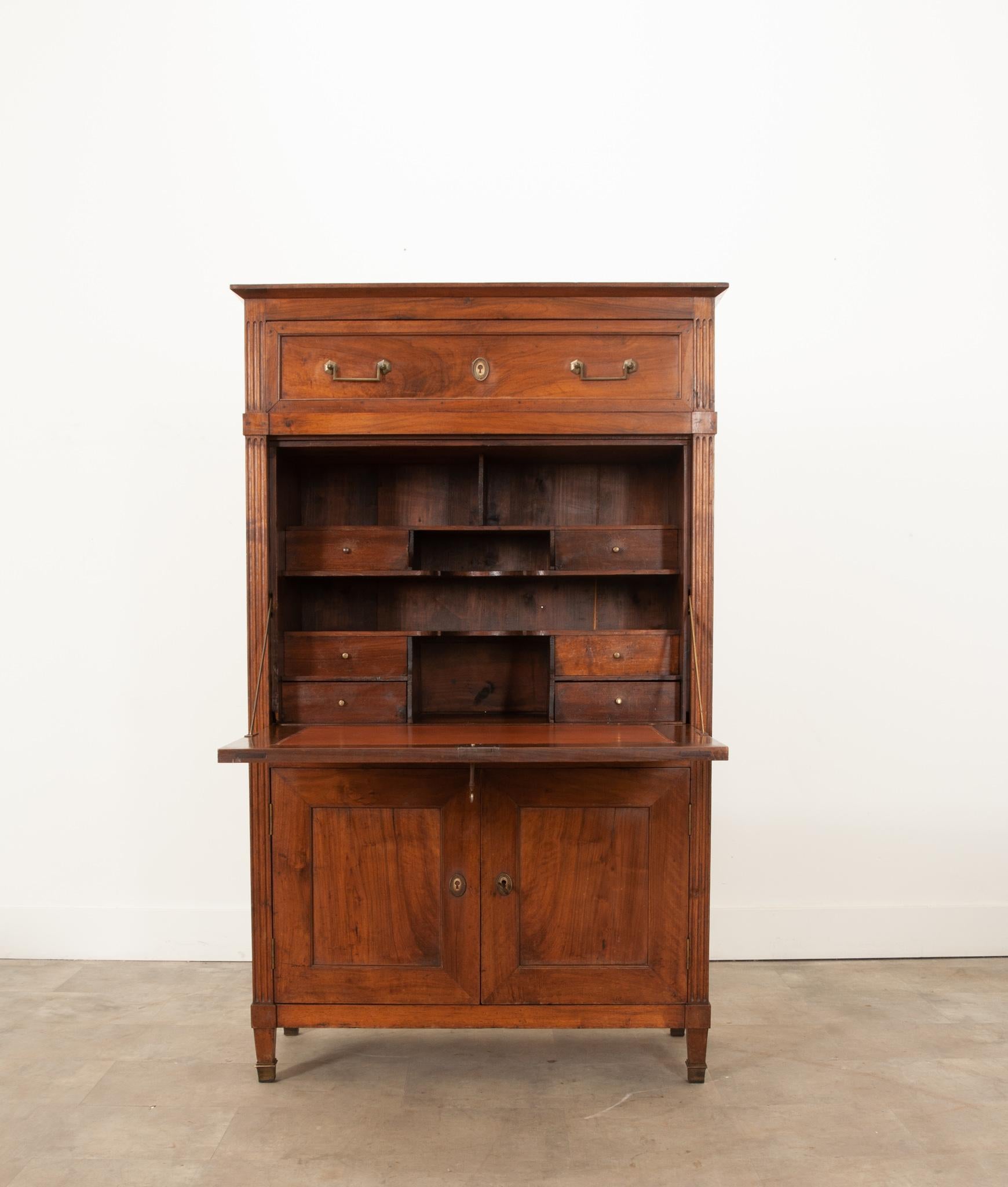 An impressive solid walnut secretaire a abattant from 19th century France. This specialized antique serves a distinct function as a writing desk, while also providing excellent storage in its series of drawers and cabinets. One large drawer that