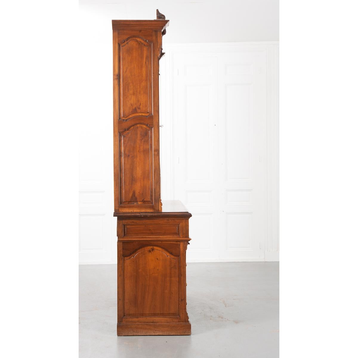 A wonderful French 19th century walnut secretary/bookcase. The piece can be separated into two bodies: the lower writing surface, and the upper glass-front cabinet. The writing surface is covered in black leather and can be pulled out for additional