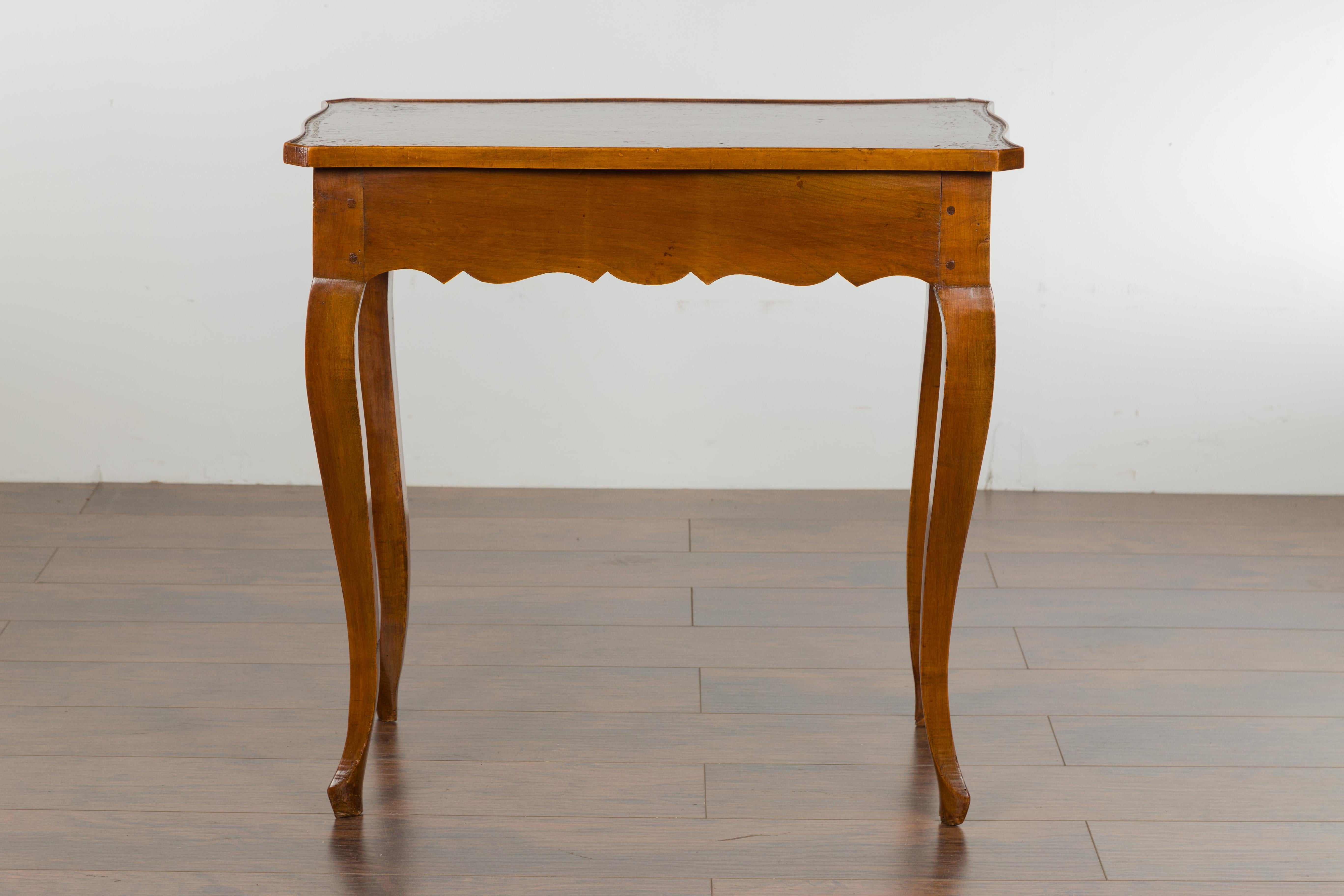 A French walnut side table from the 19th century, with leather top, long lateral drawer and cabriole legs. Created in France during the 19th century, this walnut side table features a rectangular shaped top with leather inset and canted corners,