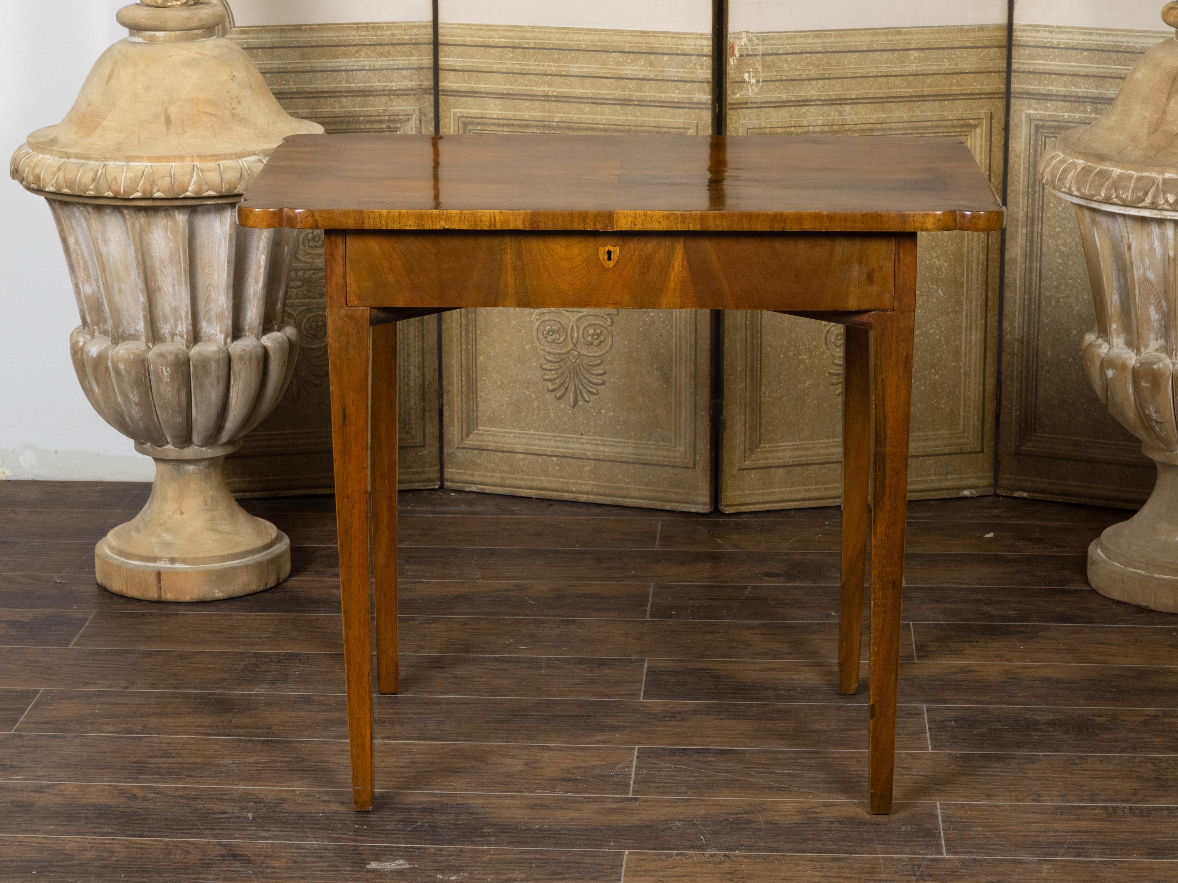 A French walnut side table from the 19th century, with quarter veneered top, protruding rounded corners, single drawer and tapered legs. Created in France during the 19th century, this walnut side table features an exquisite quarter veneered top