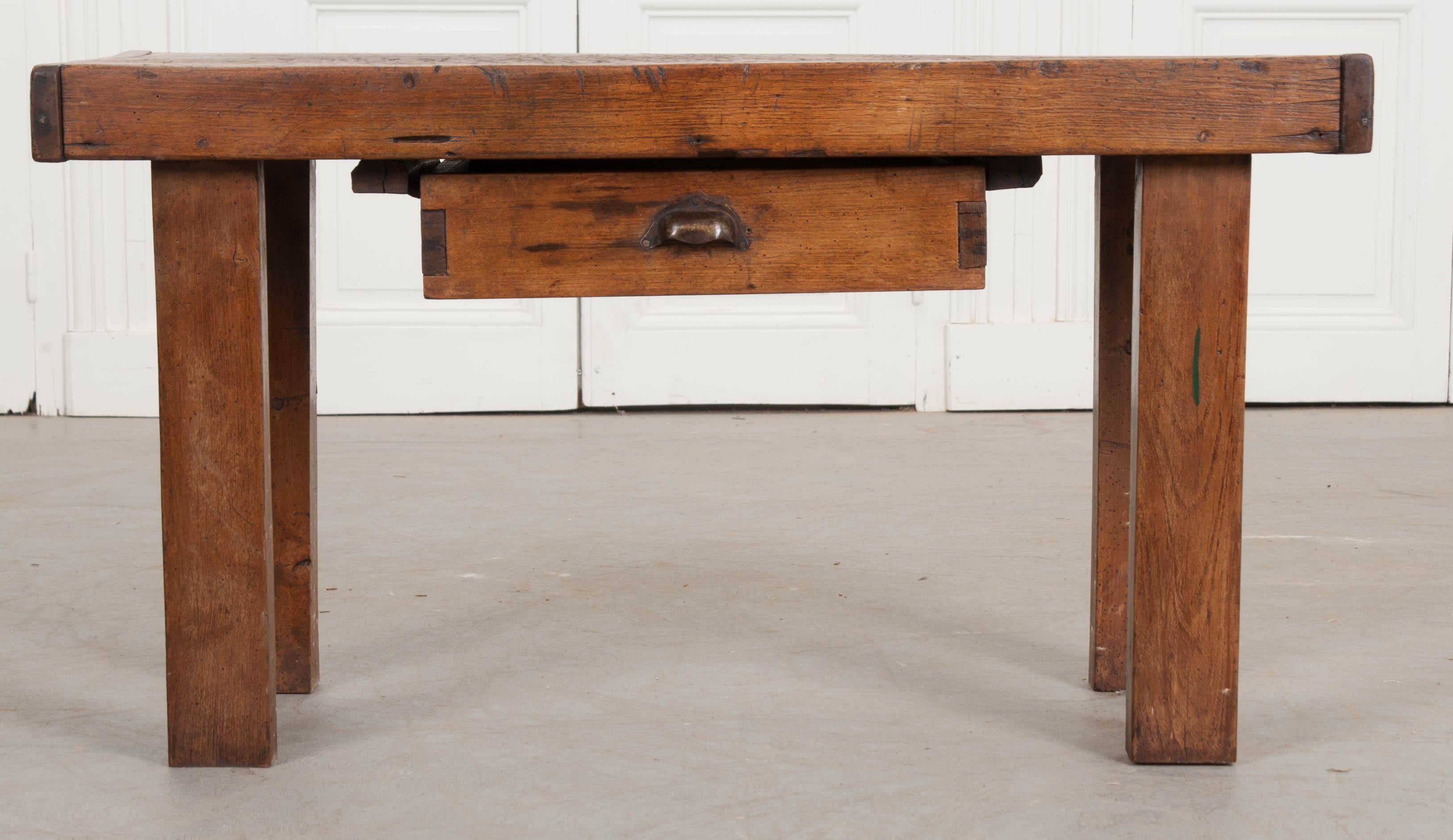 Converted from an antique walnut workbench, this excellent coffee table comes from 19th century France. The top has seen many projects through to completion, as made evident by the scores of scratches, scrapes and gouges left from craftsmen long