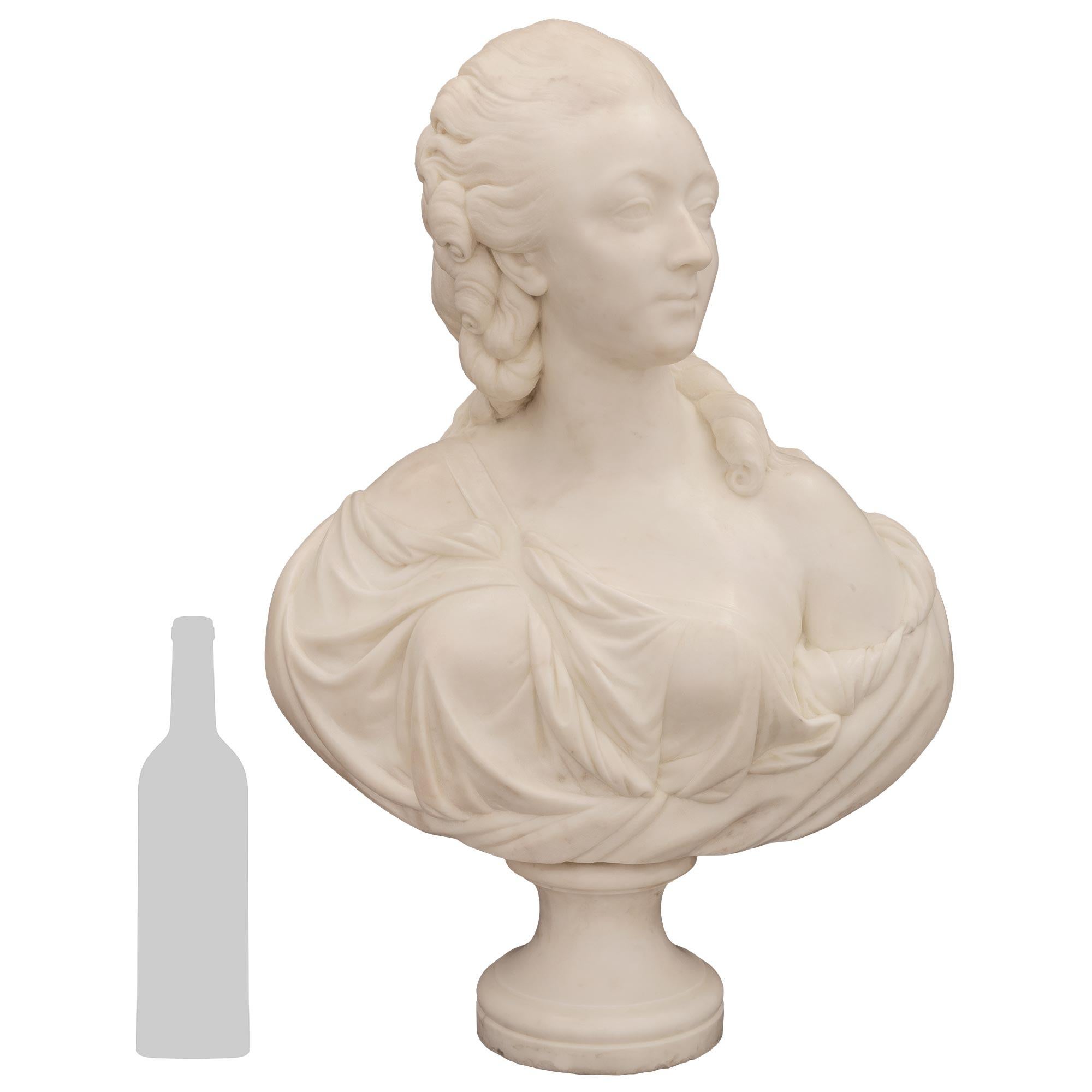 An elegant and high quality French 19th century White Carrara marble bust of La Comtesse Du Bary, in the manner of Augustin Pajou. This charming bust is raised by a fine circular socle shaped pedestal support with a lovely mottled band. The Comtesse