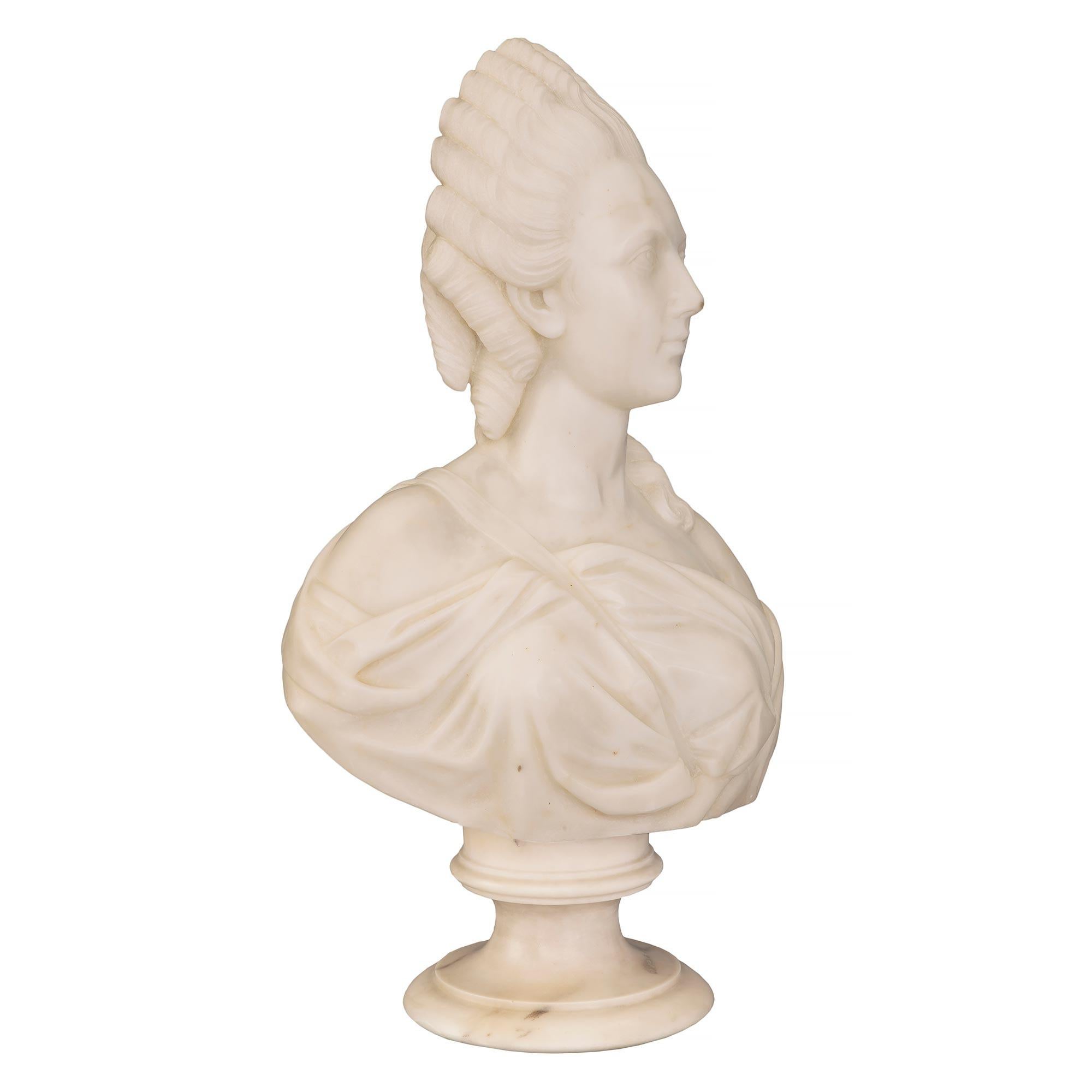 Un beau buste français du 19ème siècle en marbre blanc de Carrare représentant Marie-Antoinette. Le buste est surélevé par un socle circulaire finement moucheté. Le buste richement sculpté représente Marie-Antoinette drapée dans un élégant vêtement