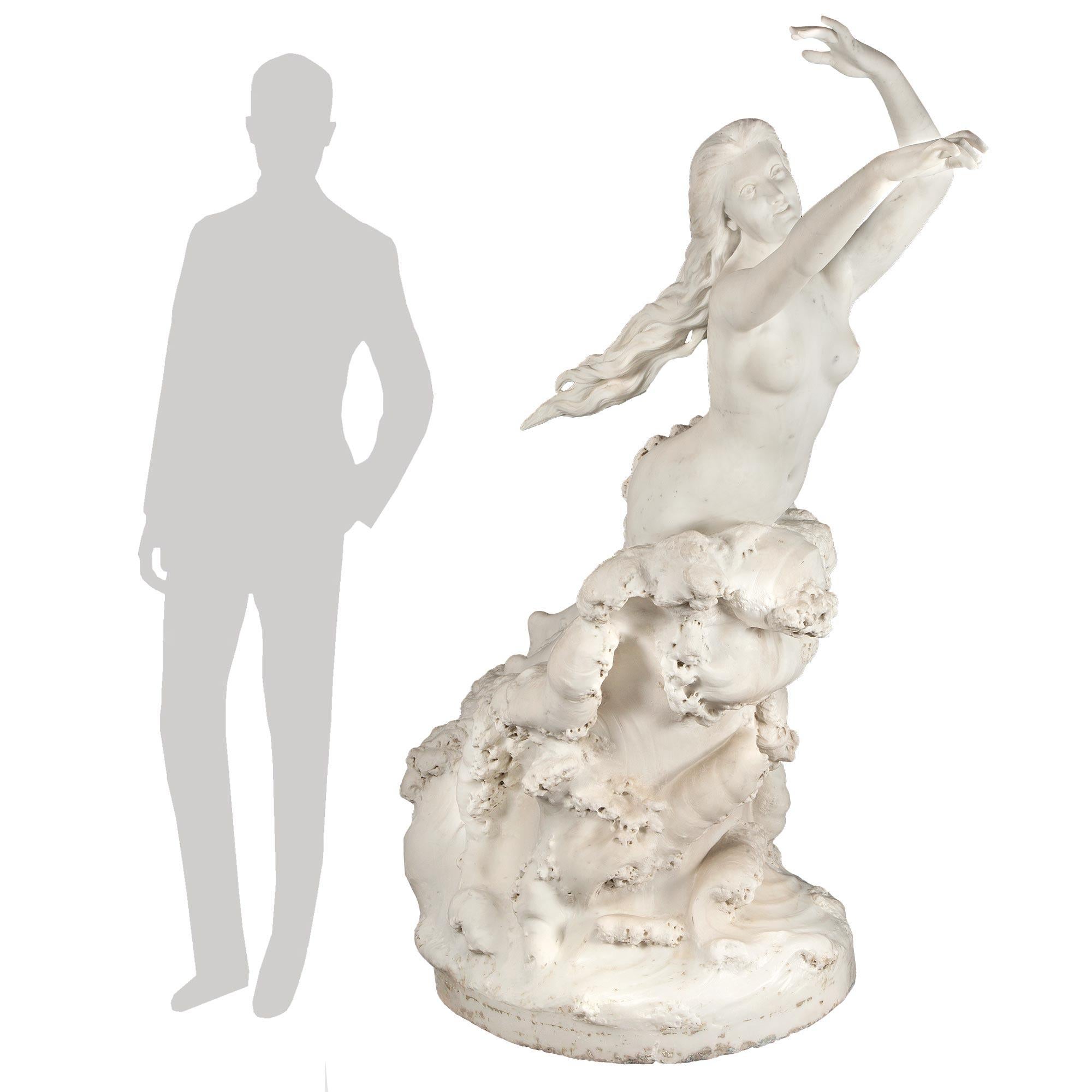Una magnifica statua in marmo bianco di Carrara del XIX secolo, molto unica e di alta qualità, firmata E. Damé, 1892. Una ninfa marina nuda che emerge dalle onde dell'oceano. Le sue braccia sono elegantemente sollevate, con i lunghi capelli