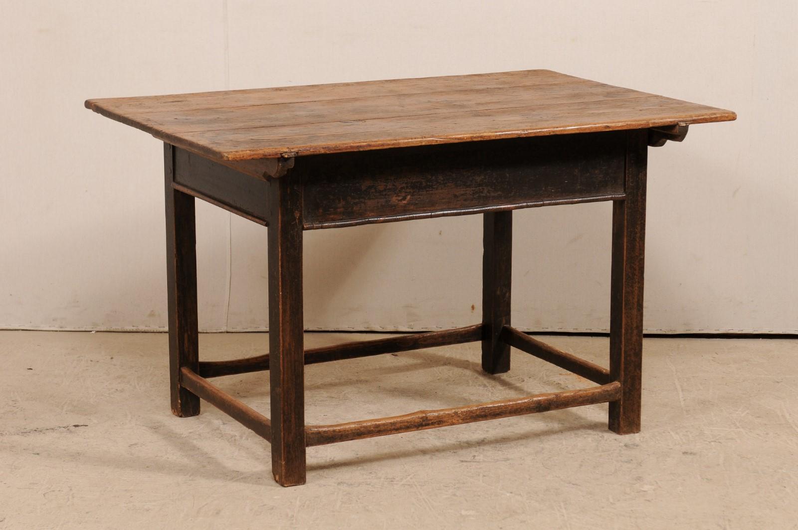 A French 19th century wood occasional table. This antique table from France is rustic and inviting with its beautifully aged, natural wood top, and base which has remnants of its original paint. The rectangular-shaped top overhangs the plain but