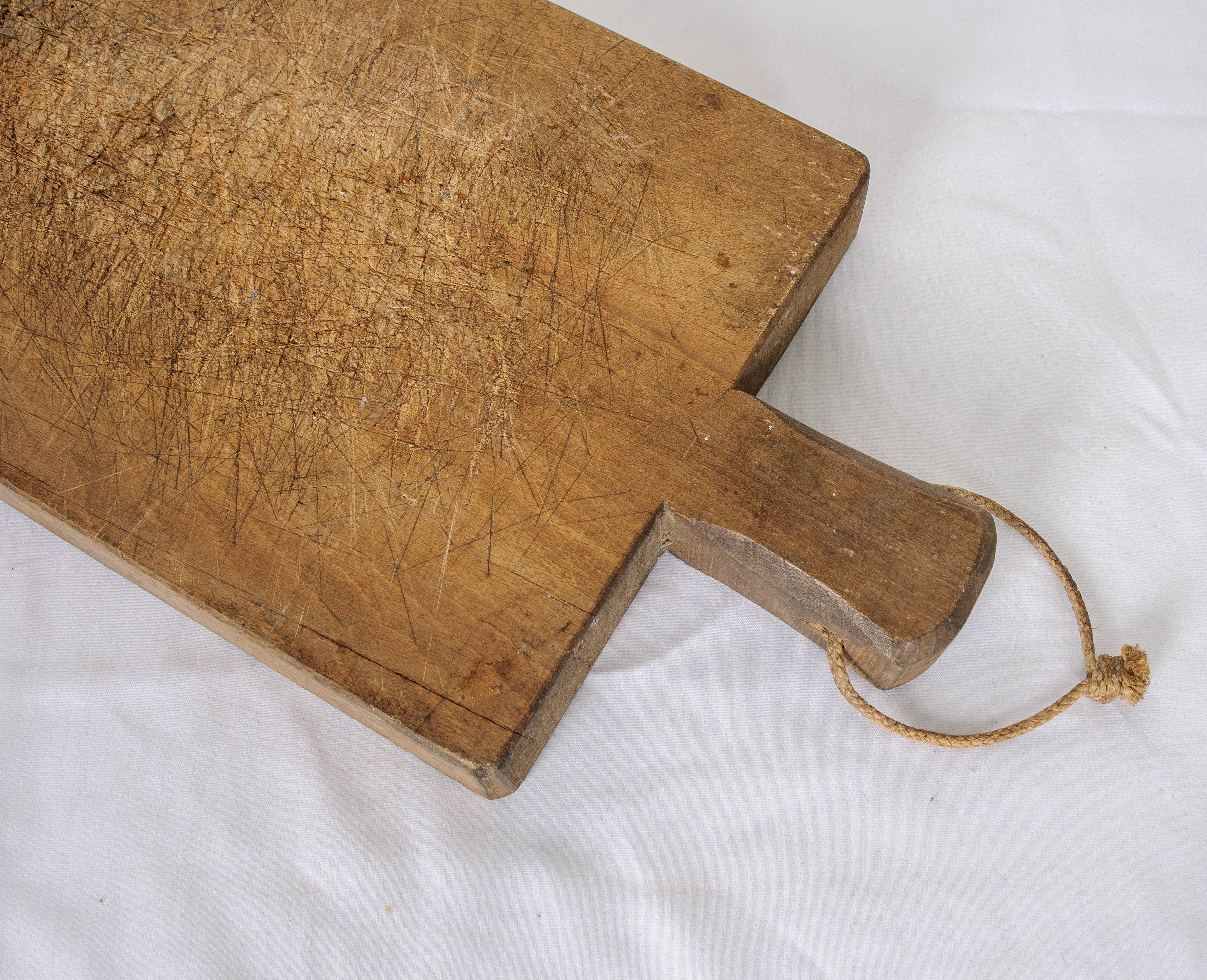 Countless marks have been left by chefs’ knives all-over this wonderful French breadboard. Made in France circa 1900, this board has helped slice up many-a-baguette! A handle provides a place to hold or hang the antique kitchen implement. These