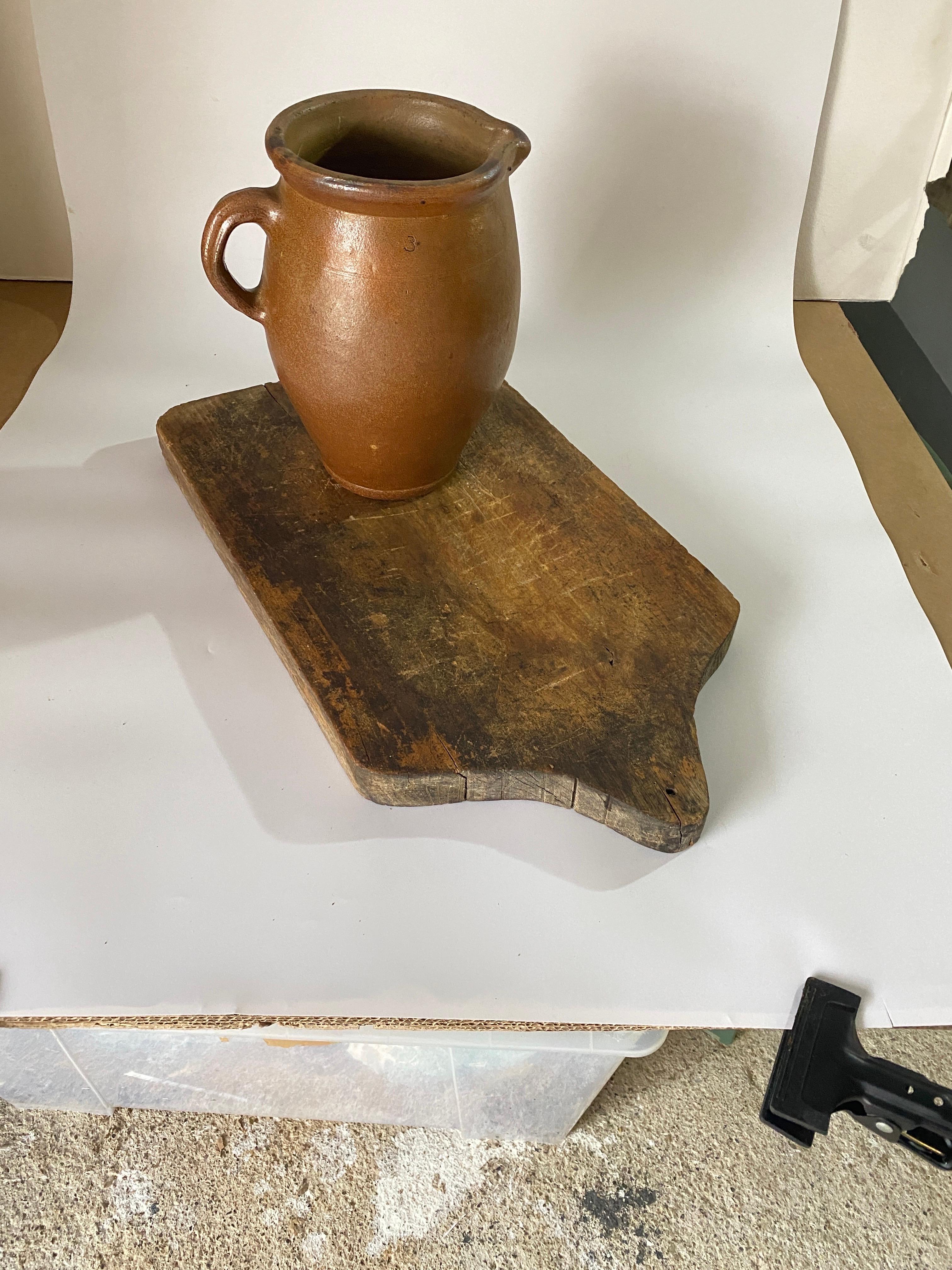 Wooden cutting board, with its old patina. It is an object of the French 19th century, in the style of French Provincial which is brown in color, and in a condition consistent with its age and use.